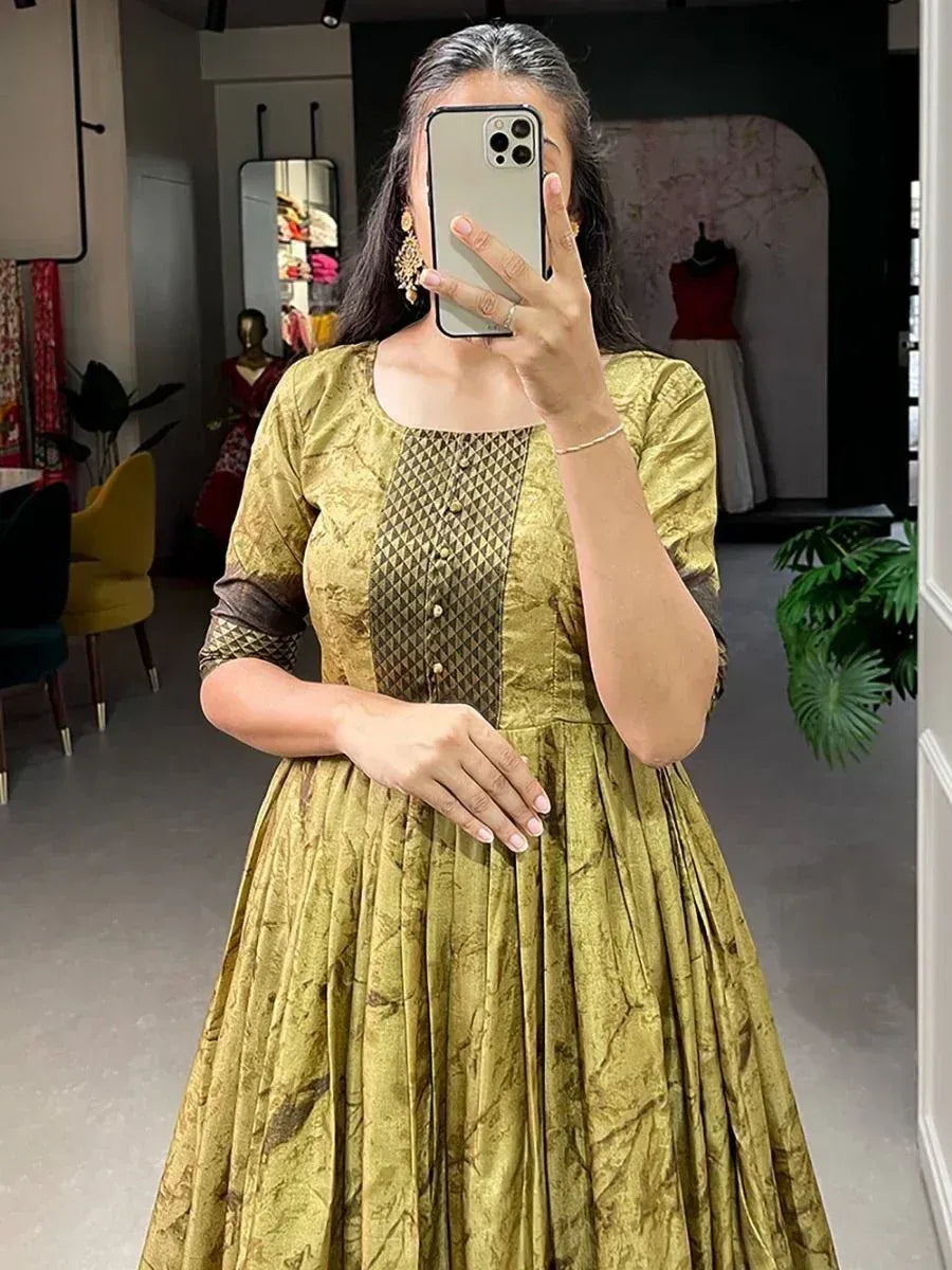 Woman in gold ethnic gown with pleated skirt and geometric panel, perfect for Indian occasions