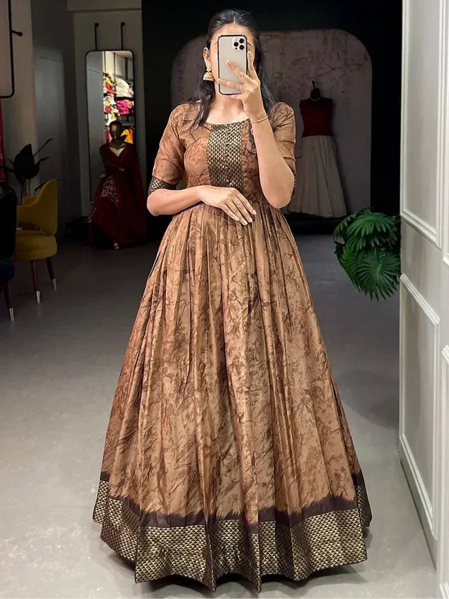 Woman in brown printed ethnic gown with net detailing, perfect for Indian occasions and festive wear.
