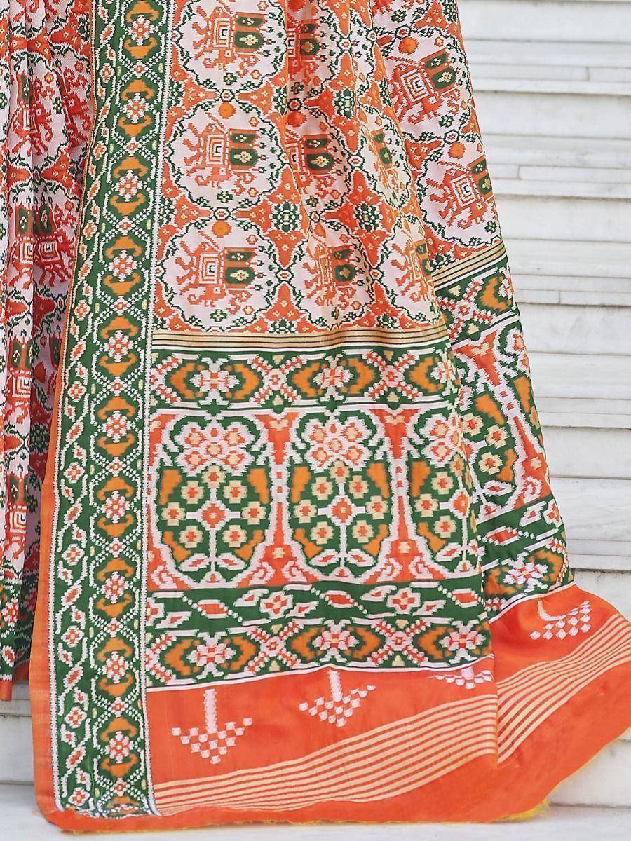 Vibrant orange and green printed ethnic saree with intricate geometric patterns and border design