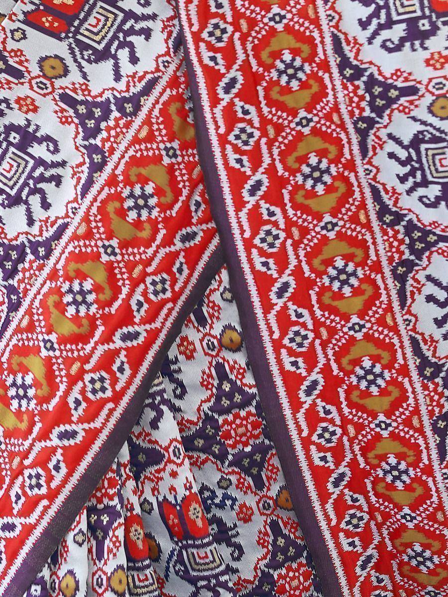 Vibrant red and purple ethnic print fabric with intricate geometric and floral patterns, ideal for designer lehenga or saree.