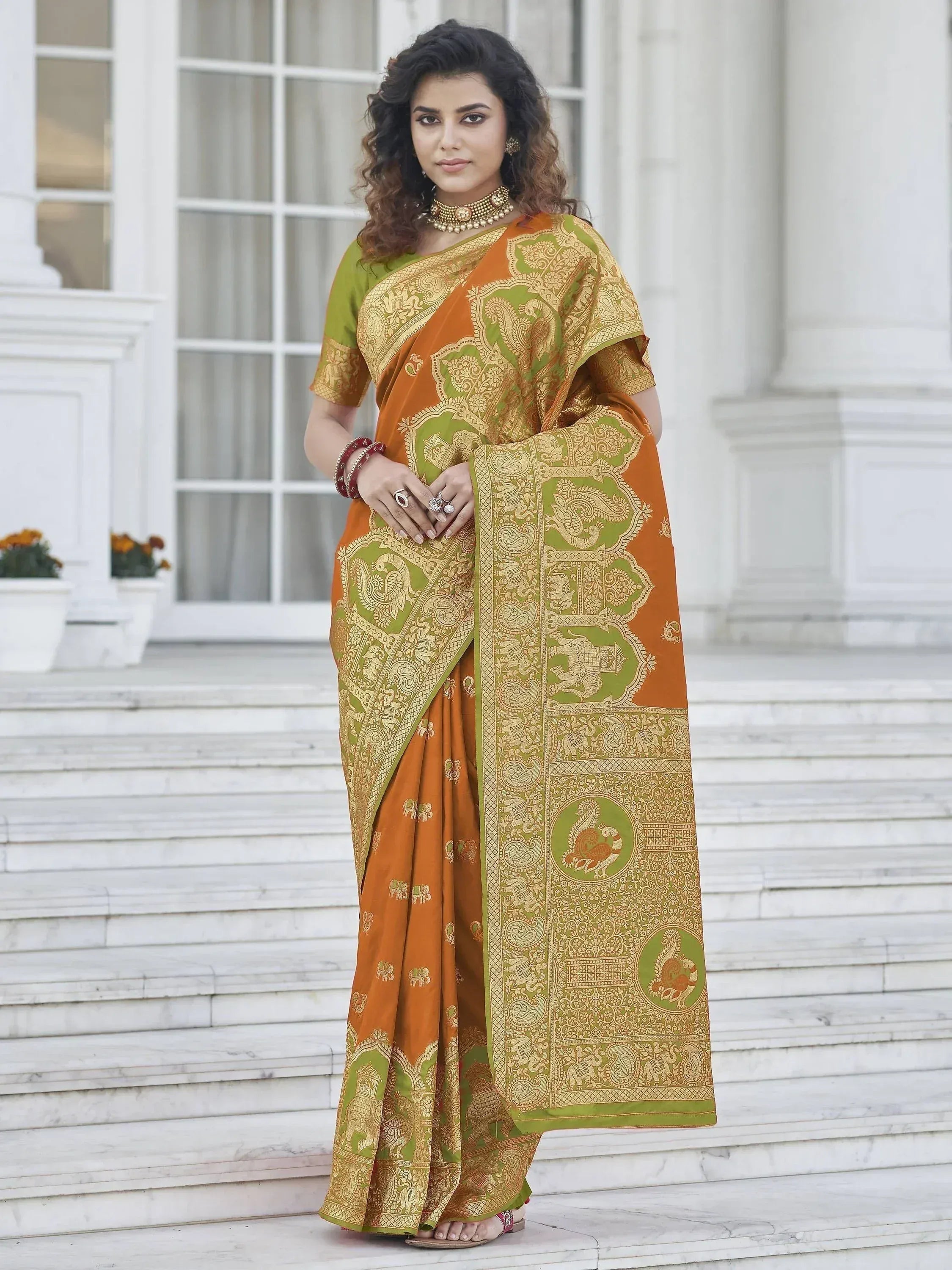 Orange and green designer saree with gold paisley and elephant motifs, perfect for ethnic occasions