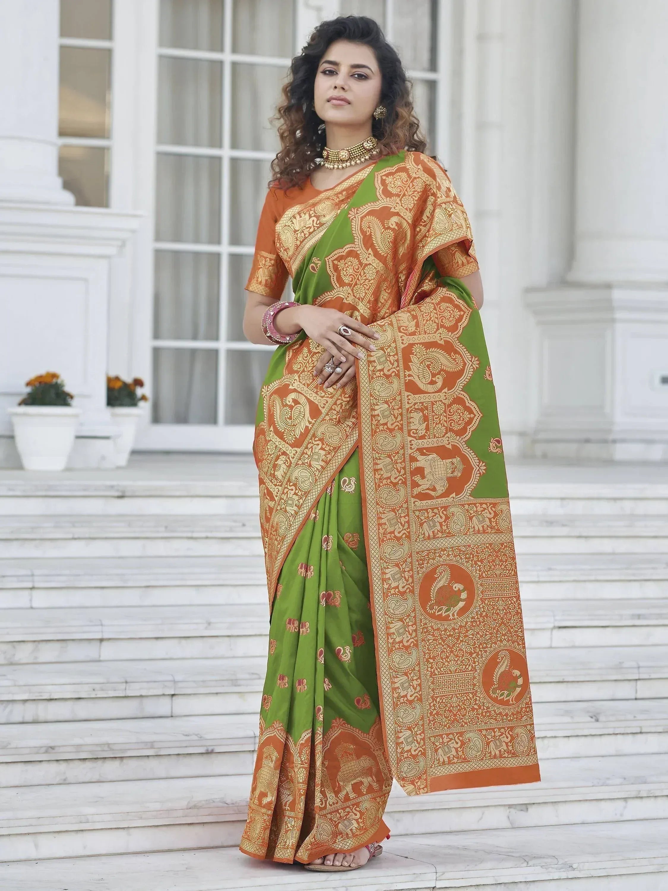Green and orange designer saree with gold paisley and elephant motifs, perfect for ethnic occasions