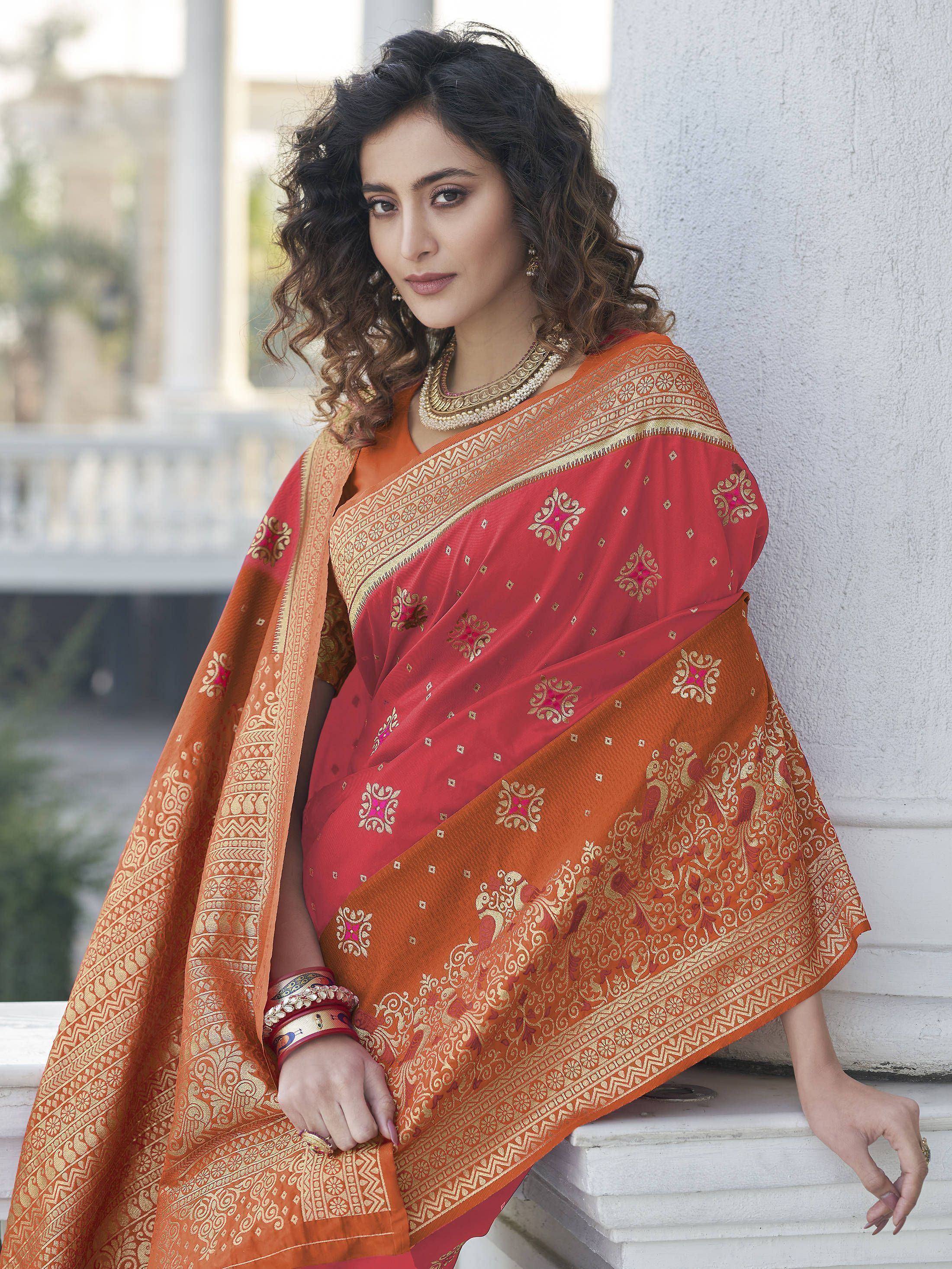 Woman in red and orange embroidered saree with gold border, traditional Indian ethnic wear