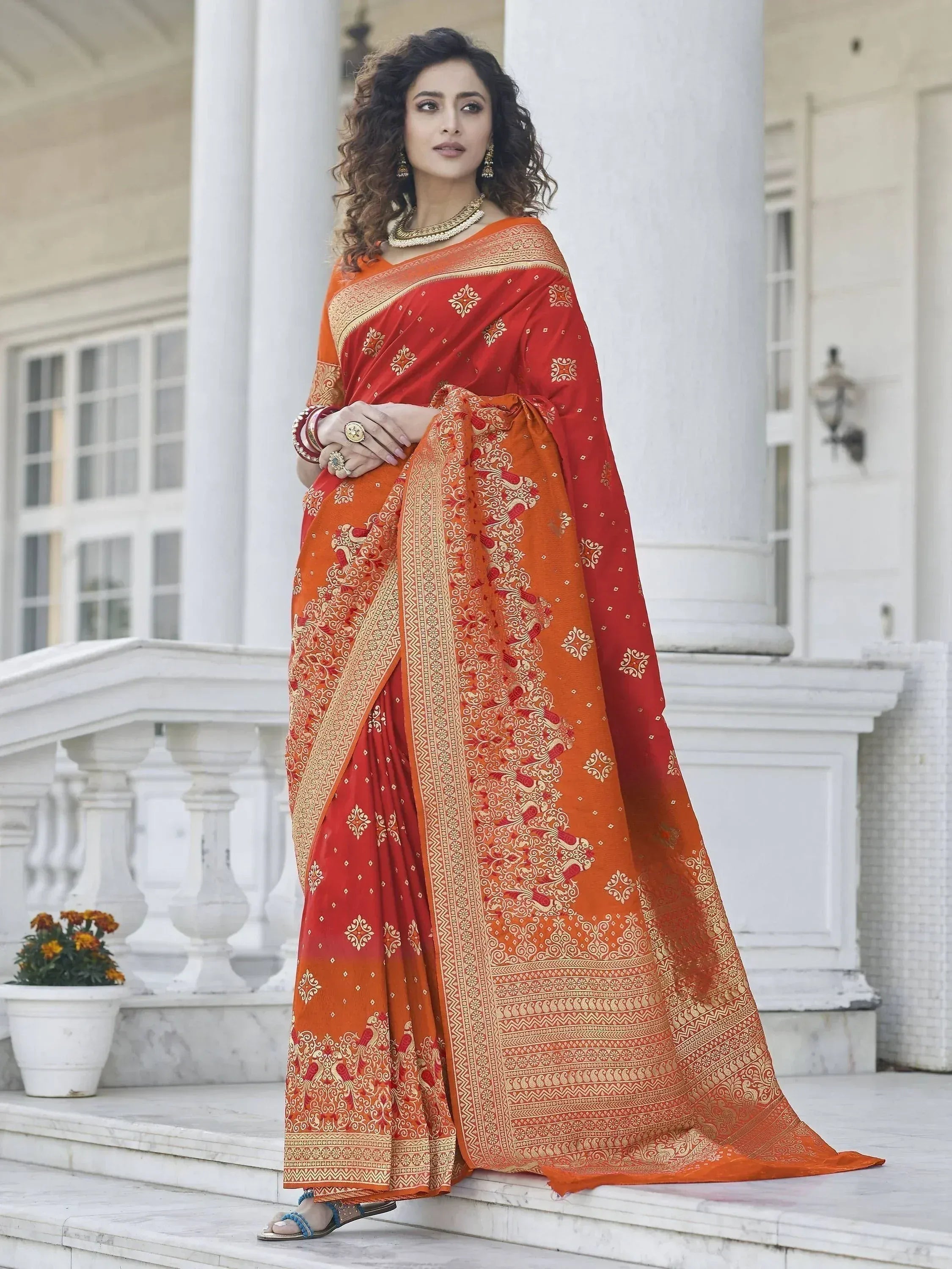 Elegant red and orange saree with gold embroidery, perfect for Indian ethnic wear occasions.