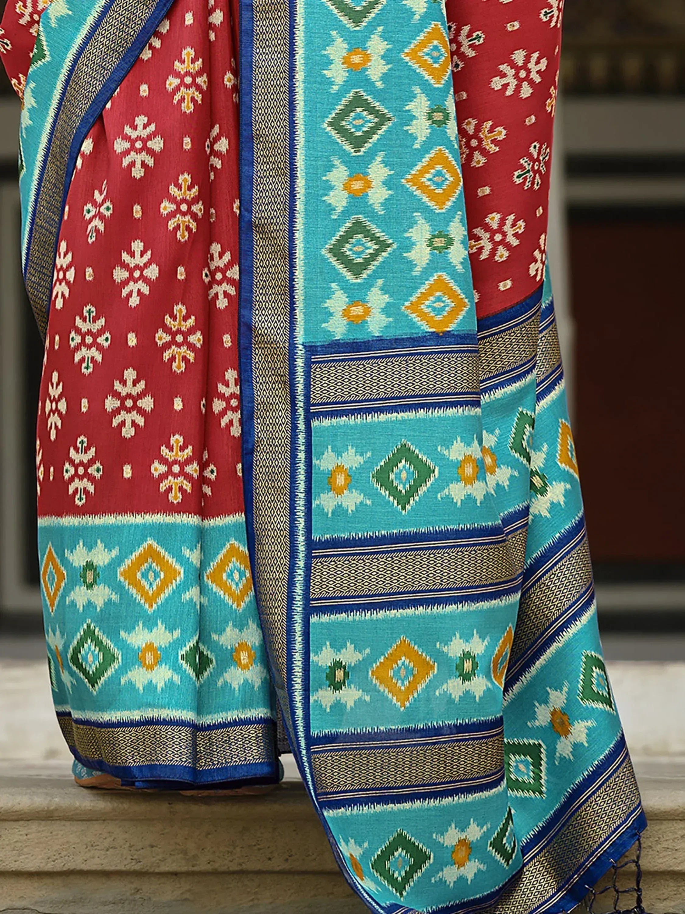 Red and turquoise ethnic saree with geometric ikat patterns and woven border