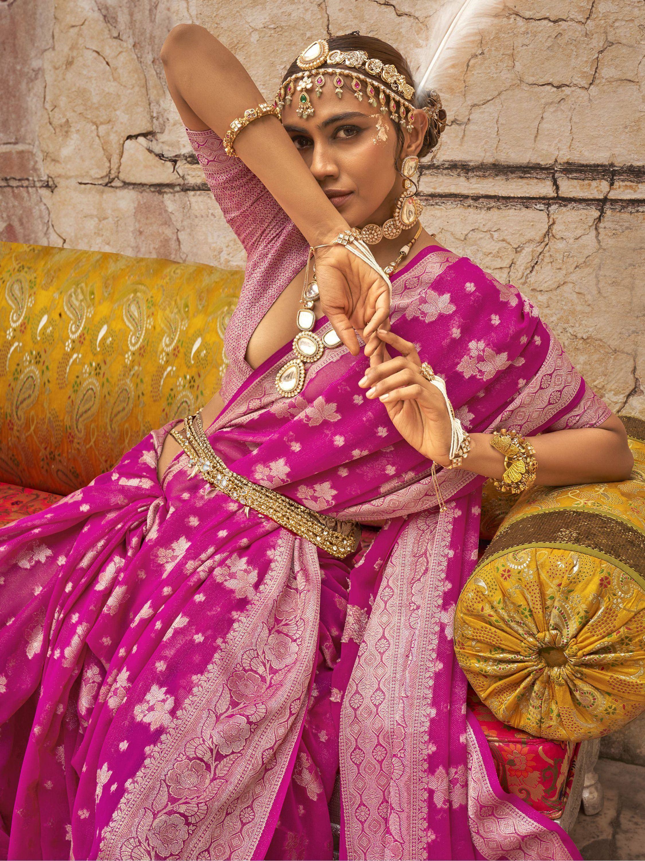 Woman in vibrant pink designer saree with gold jewelry, ethnic wear for festive occasions