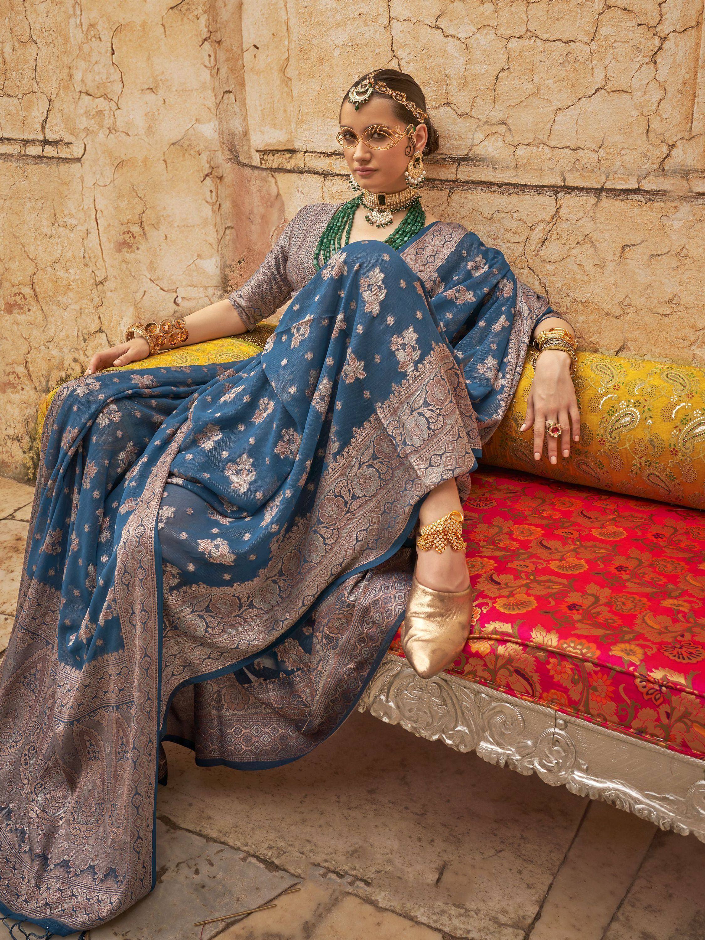 Blue floral printed ethnic saree with gold embroidery, paired with traditional jewelry and gold heels.