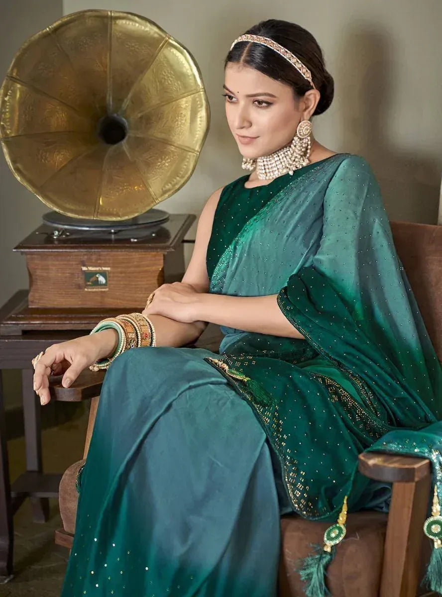 Elegant woman in emerald green ethnic saree with pearl jewelry, seated beside vintage gramophone