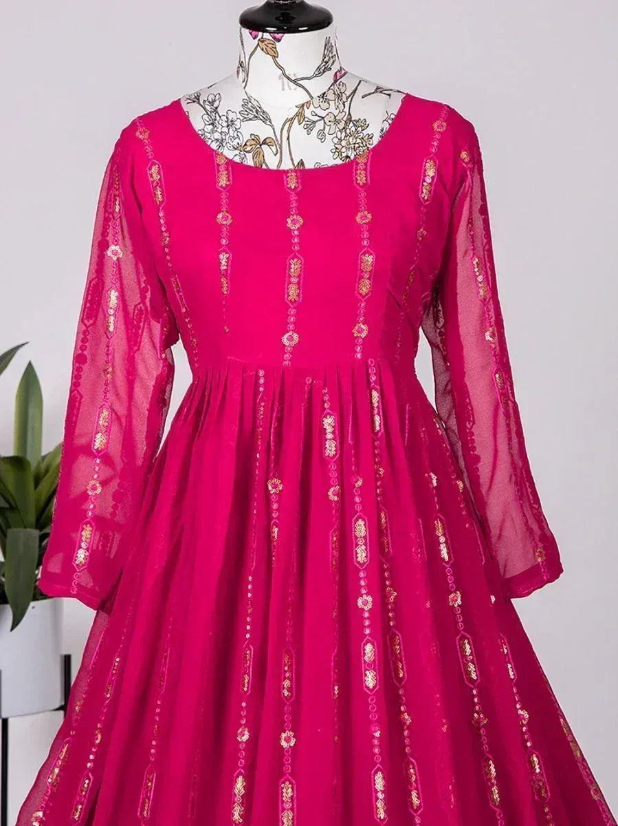 Fuchsia ethnic gown with gold embroidery, sheer sleeves, and flared skirt for Indian wear