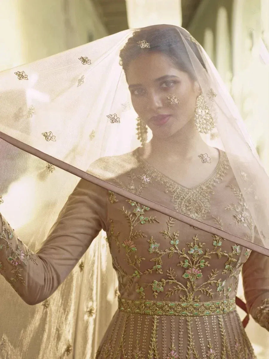 Elegant Indian bridal gown with gold floral embroidery, sheer dupatta, and statement earrings for wedding wear