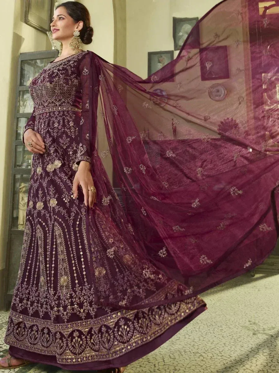 Elegant maroon ethnic gown with gold embroidery and flowing dupatta, perfect for Indian weddings and festive occasions.