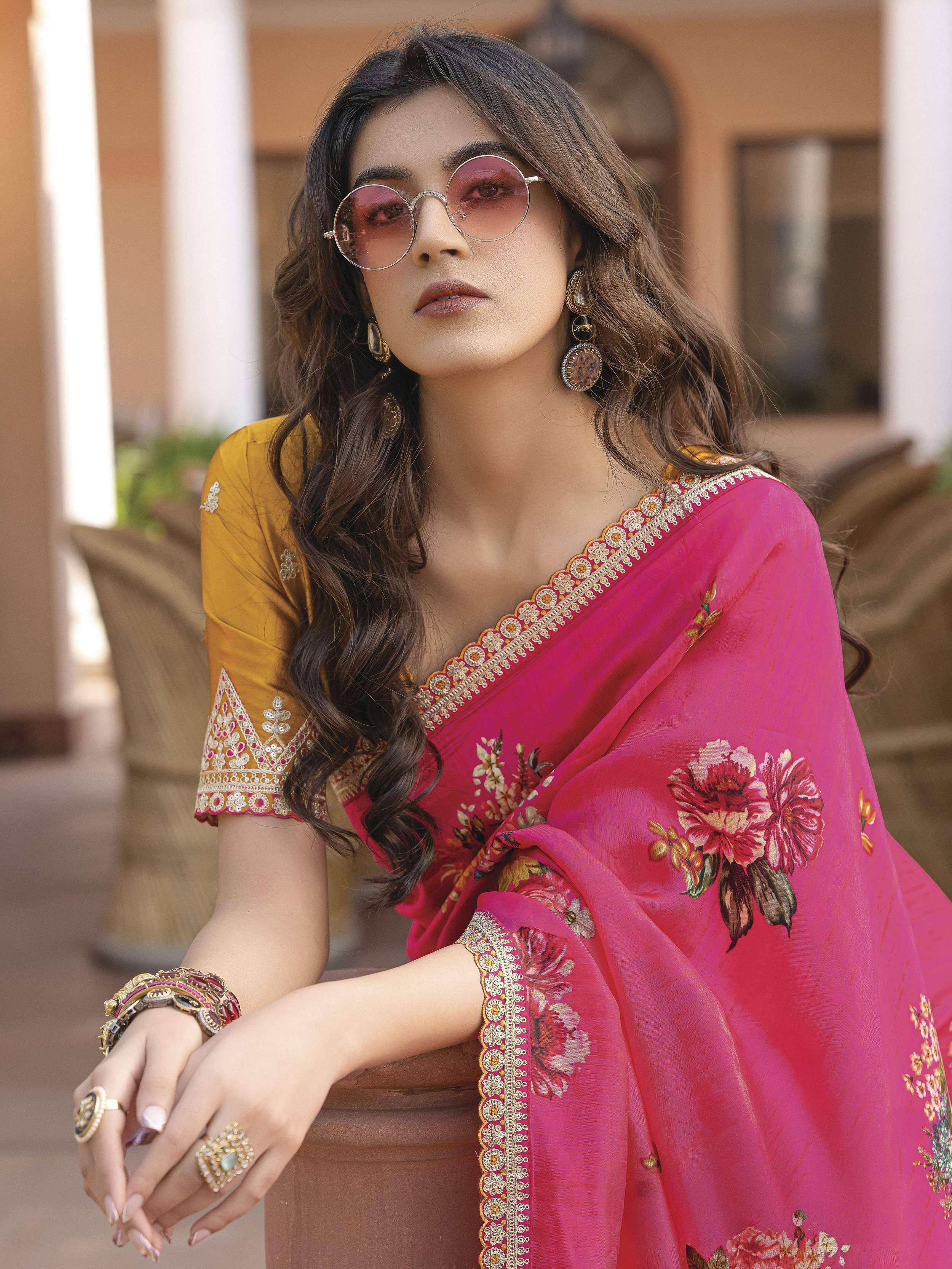 Woman in pink floral saree with yellow blouse, ethnic jewelry, and sunglasses