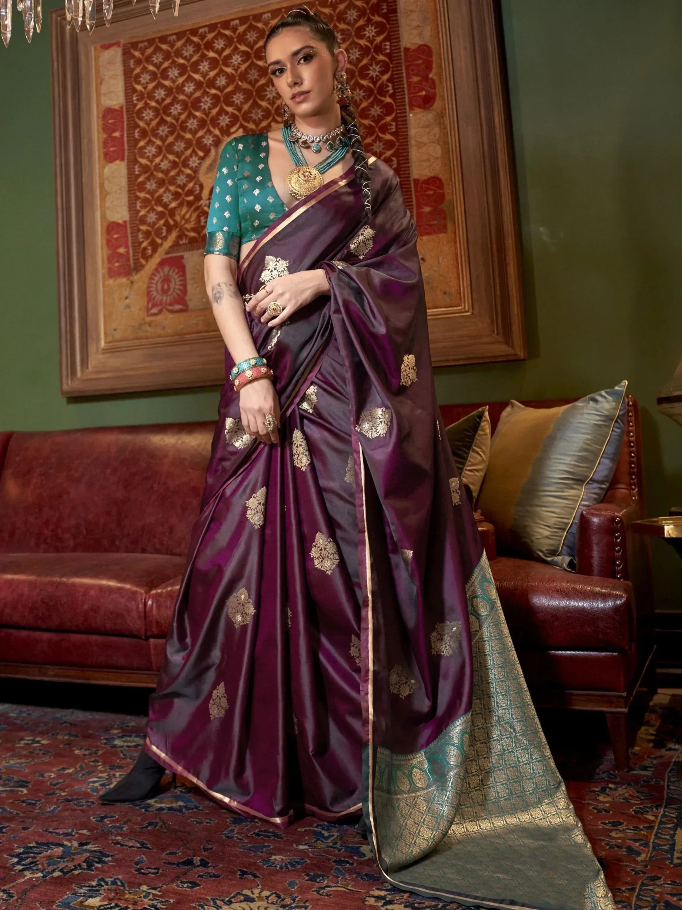 Elegant purple saree with gold floral motifs and teal blouse, styled with traditional jewelry for festive occasions.