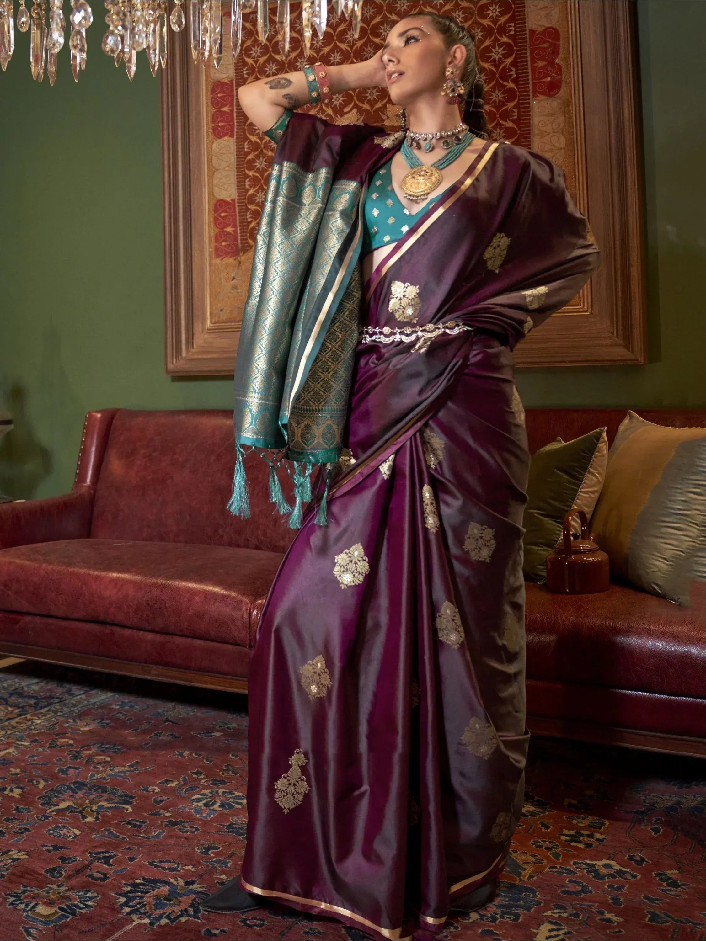 Elegant purple saree with gold embroidery and teal blouse, styled with traditional jewelry for festive occasions.