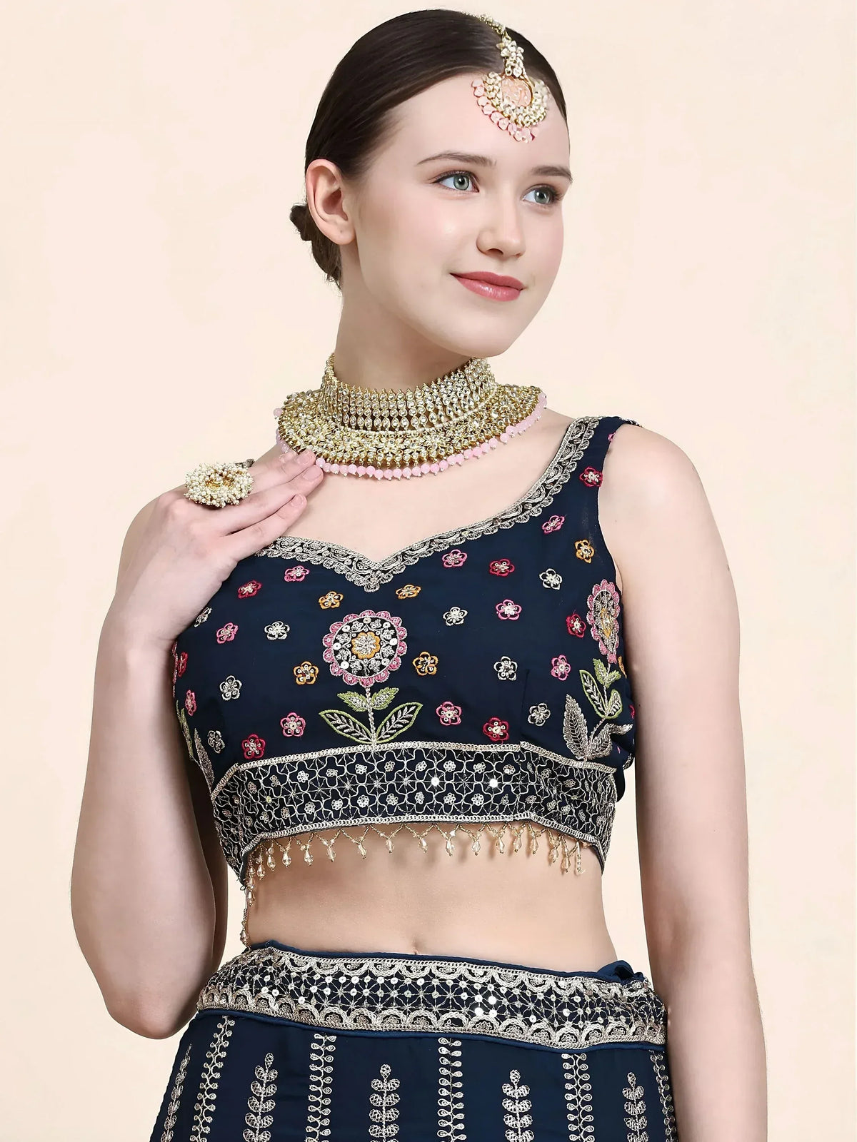 Navy blue embroidered lehenga choli with floral motifs, gold detailing, and traditional Indian jewelry