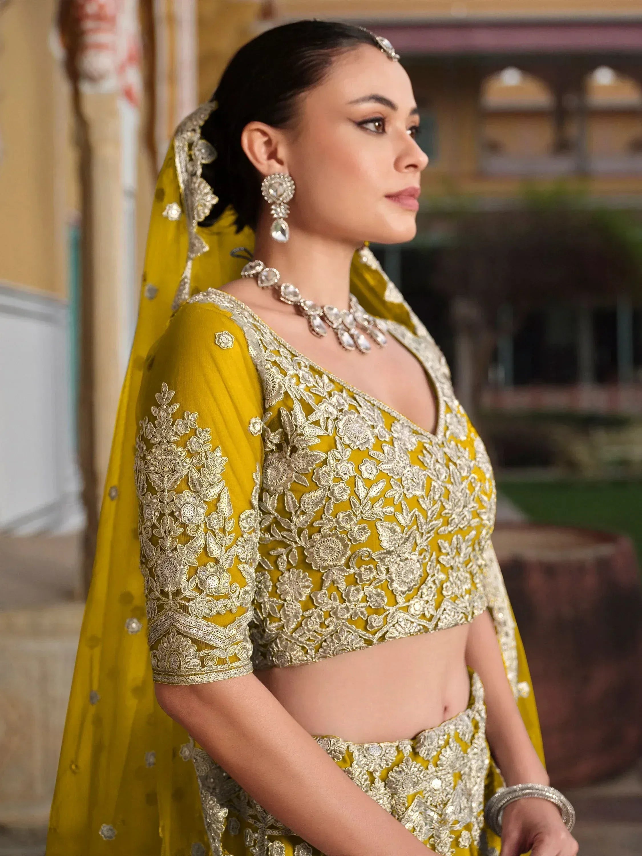 Yellow embroidered lehenga choli with floral gold work, perfect for Indian weddings and festive occasions.