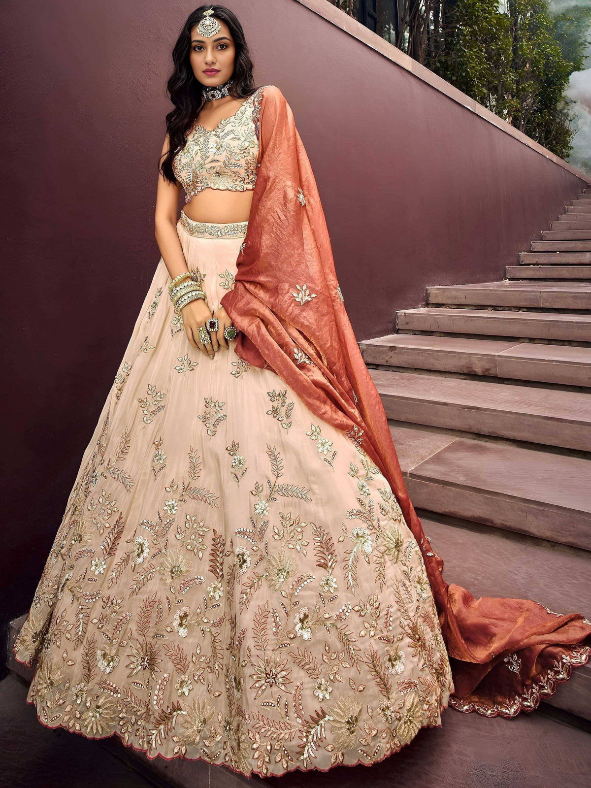 Elegant beige embroidered lehenga choli with rust dupatta, perfect for Indian weddings and festive occasions.