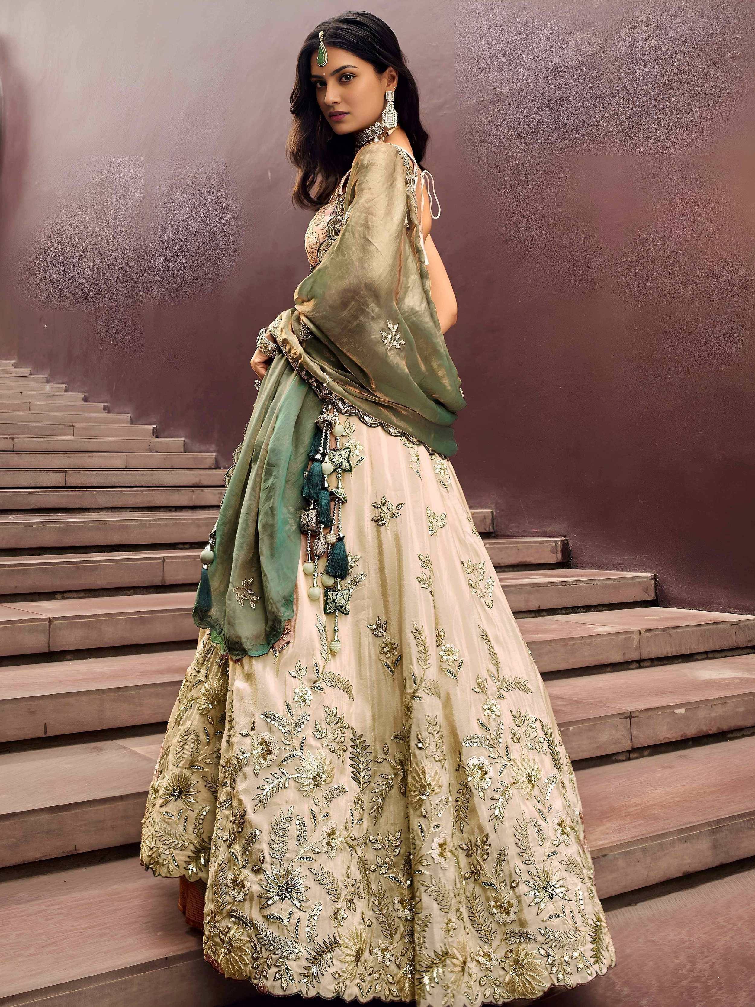 Elegant beige lehenga choli with gold embroidery and green dupatta, perfect for Indian weddings and festive occasions.