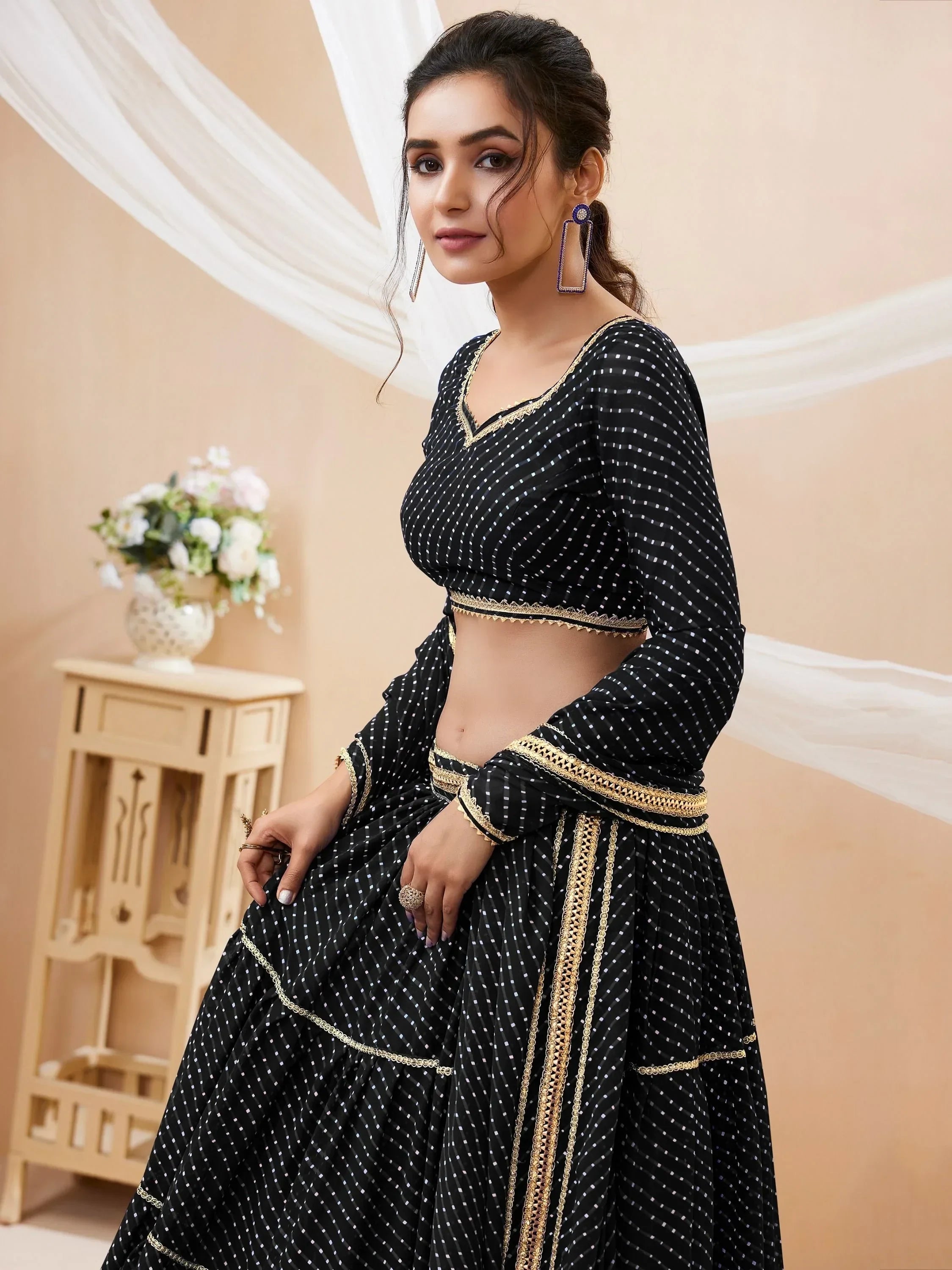 Black and gold polka dot lehenga choli with intricate embroidery, perfect for Indian ethnic wear occasions.