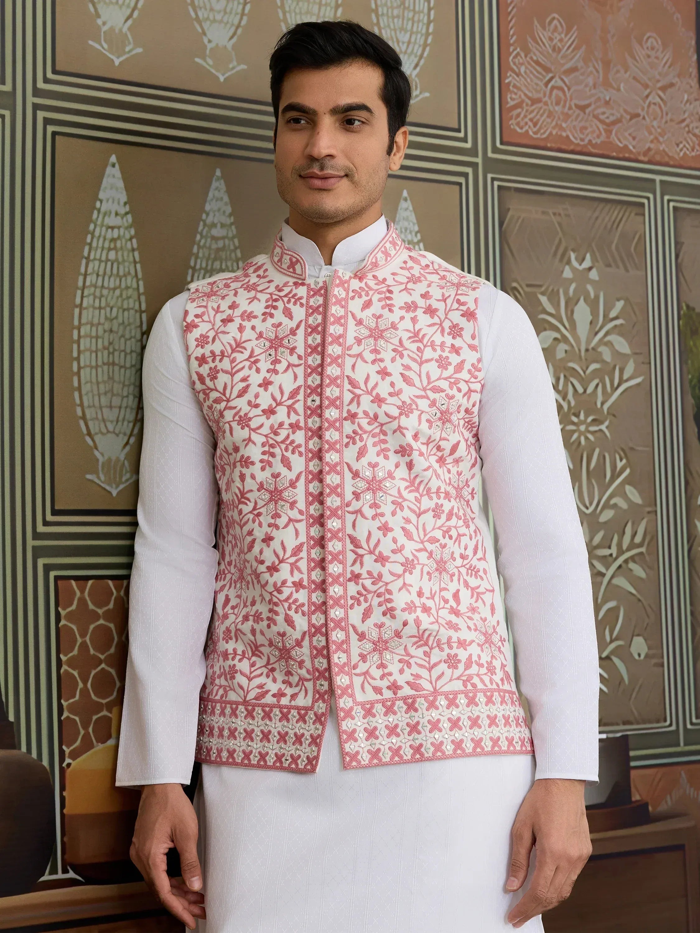 Man wearing white kurta with pink floral embroidered Nehru jacket, ideal for Indian ethnic occasions