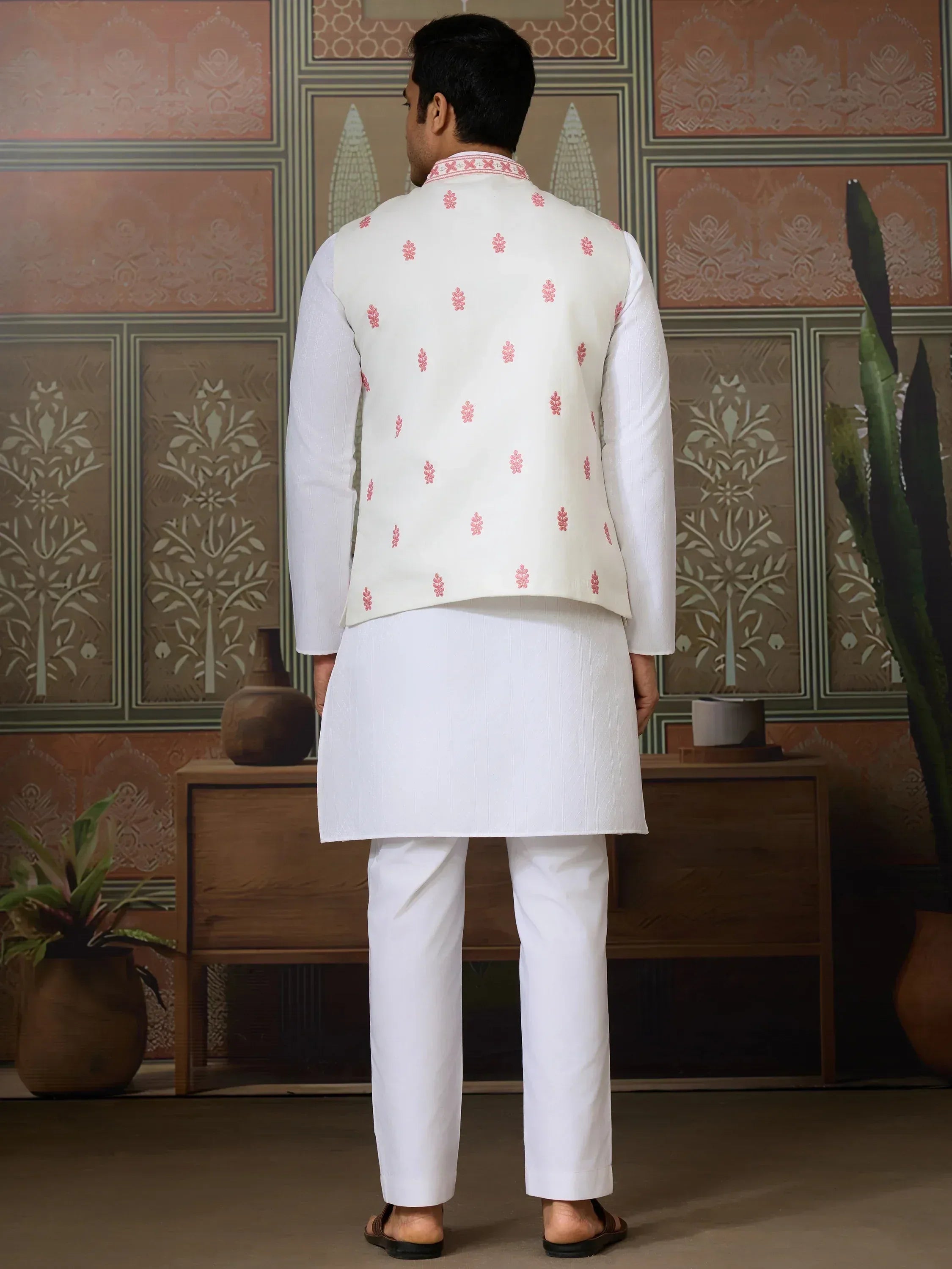 Man in white kurta pajama with pink embroidered waistcoat, back view, ethnic wear