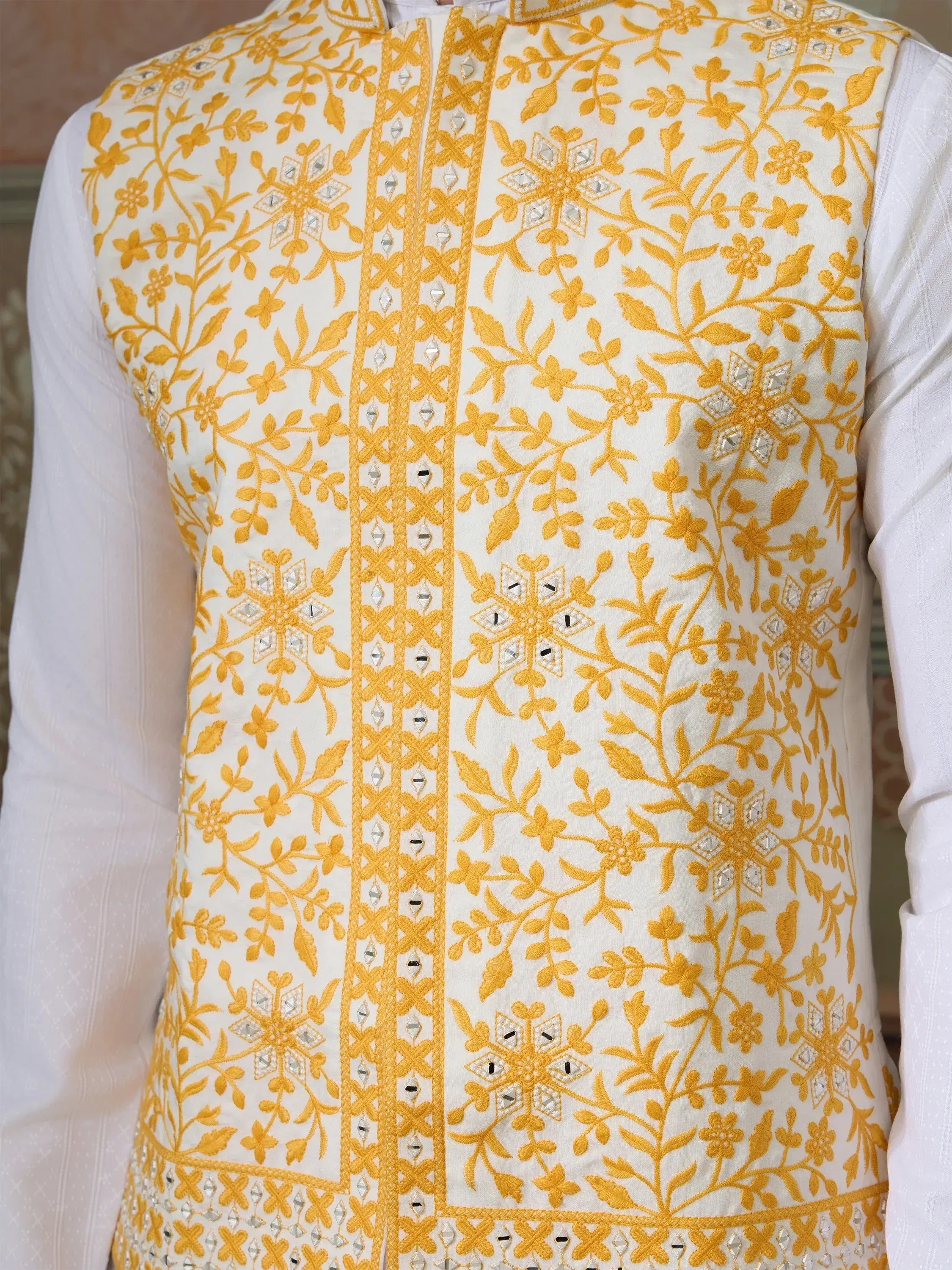 White and yellow embroidered men's ethnic vest with floral mirror work, perfect for Indian weddings or festivals.