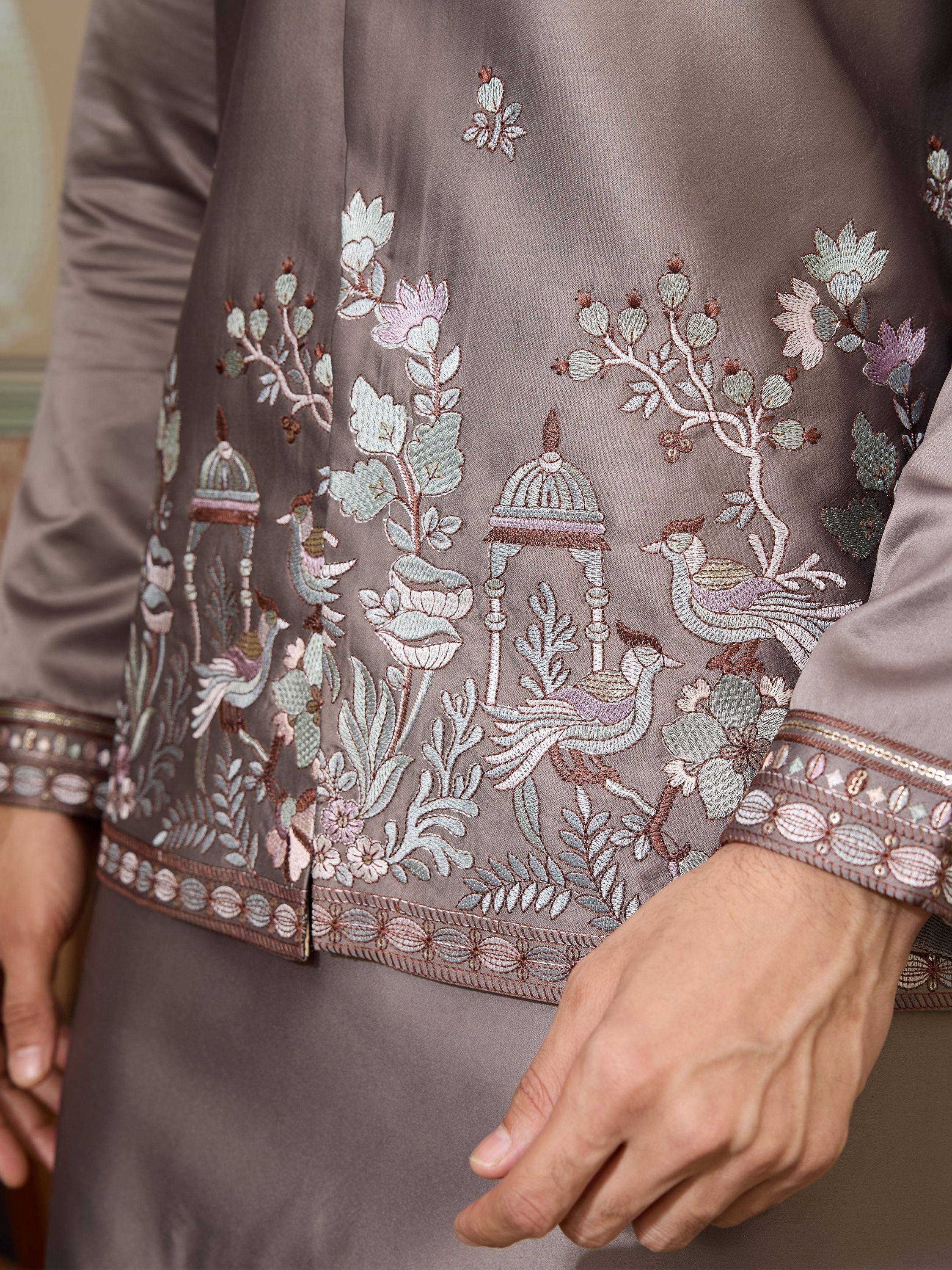 Elegant Indian ethnic wear with intricate floral and bird embroidery on satin fabric, perfect for festive occasions.