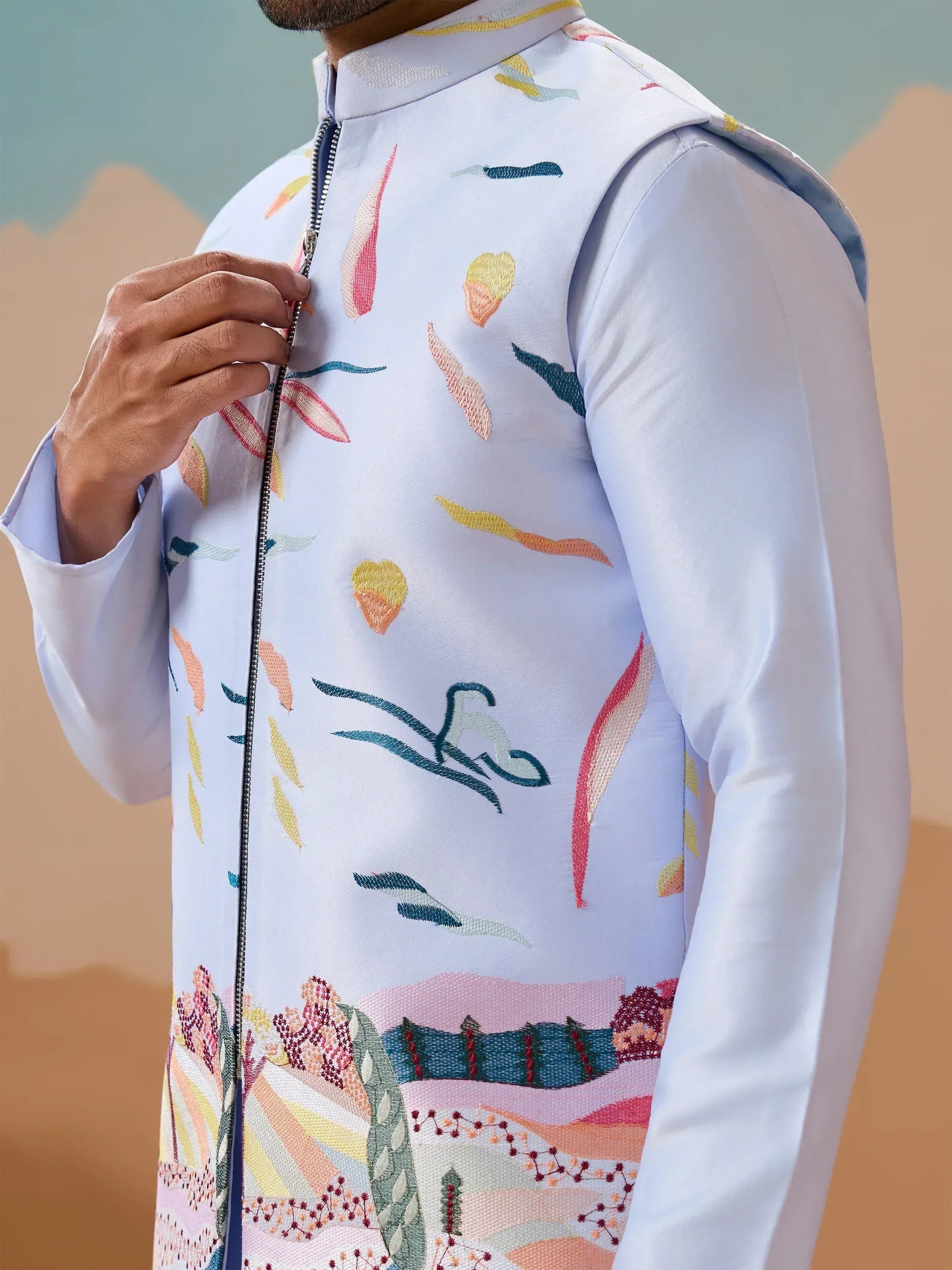 Men's embroidered white sherwani with colorful floral and landscape design, perfect for Indian ethnic wear occasions.