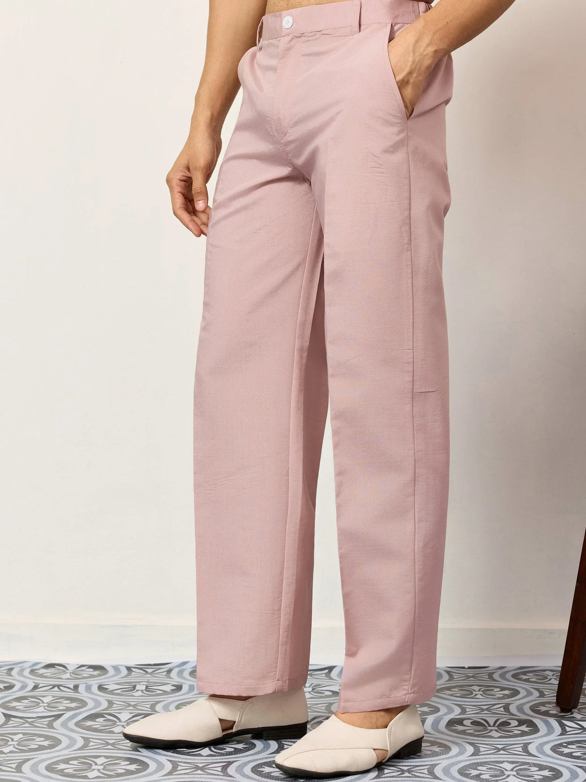 Pink wide-leg pants with white button, paired with cream loafers on patterned tile floor
