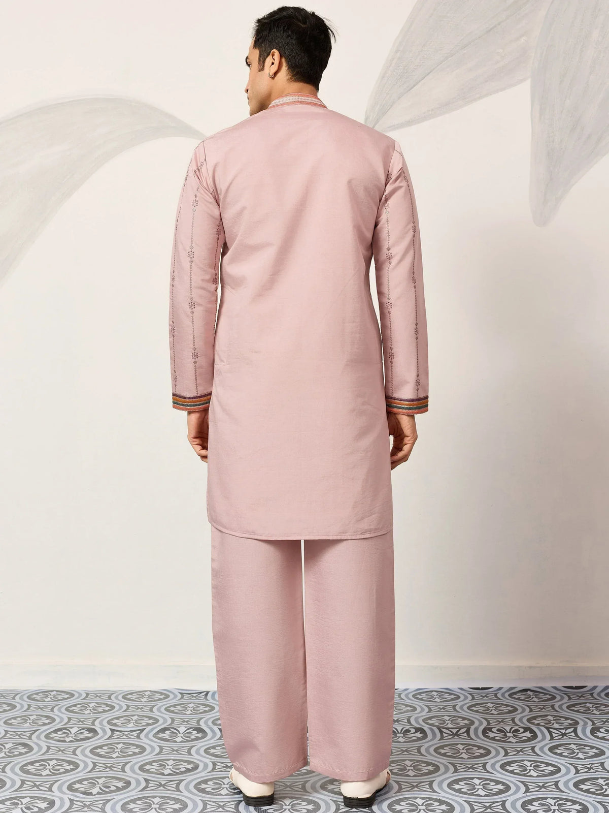 Pink men's kurta pajama set with embroidered sleeves and colorful cuffs, ideal for ethnic wear occasions.