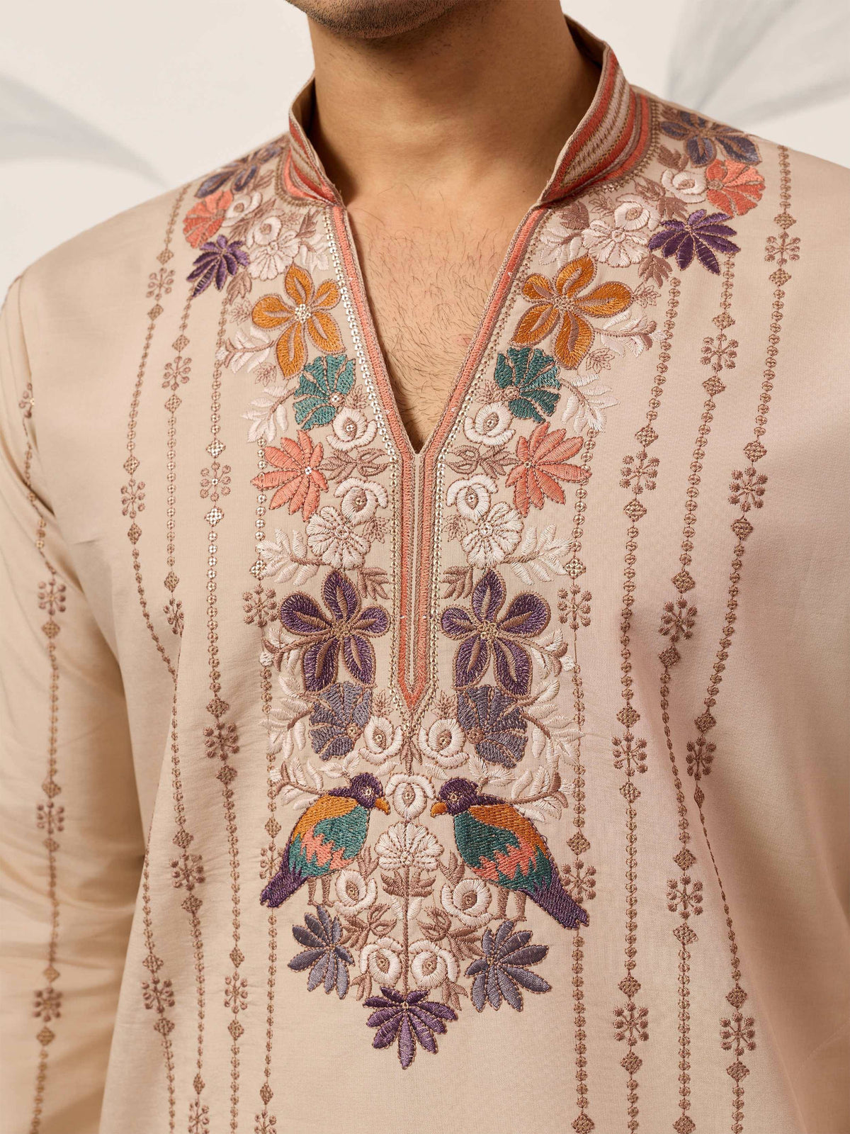 Men's beige kurta with intricate floral and bird embroidery, perfect for ethnic occasions.