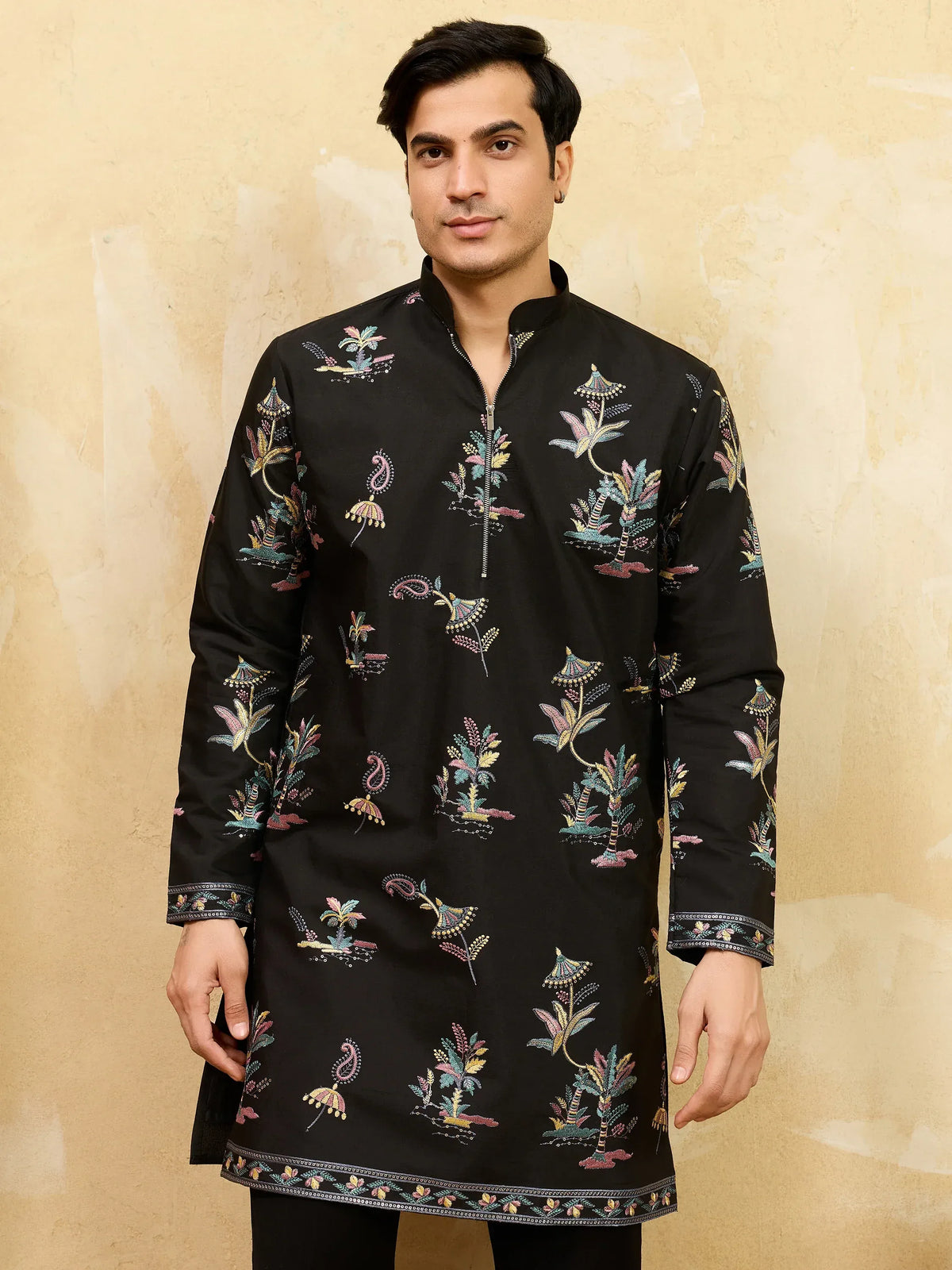 Man wearing a black embroidered Indian ethnic kurta with colorful floral patterns