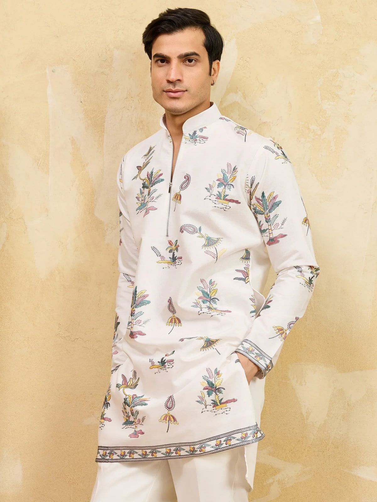 Man wearing a white printed ethnic kurta with floral designs and detailed border