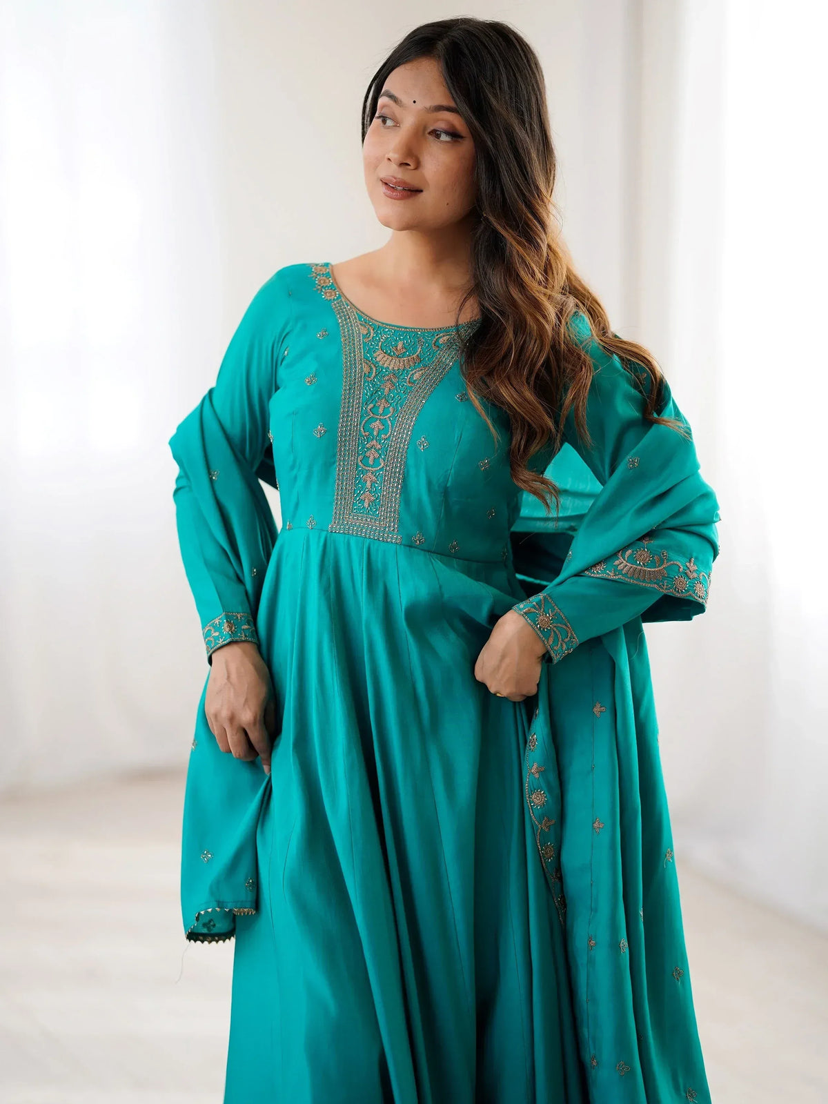Teal ethnic gown with gold embroidery, perfect for Indian festive occasions