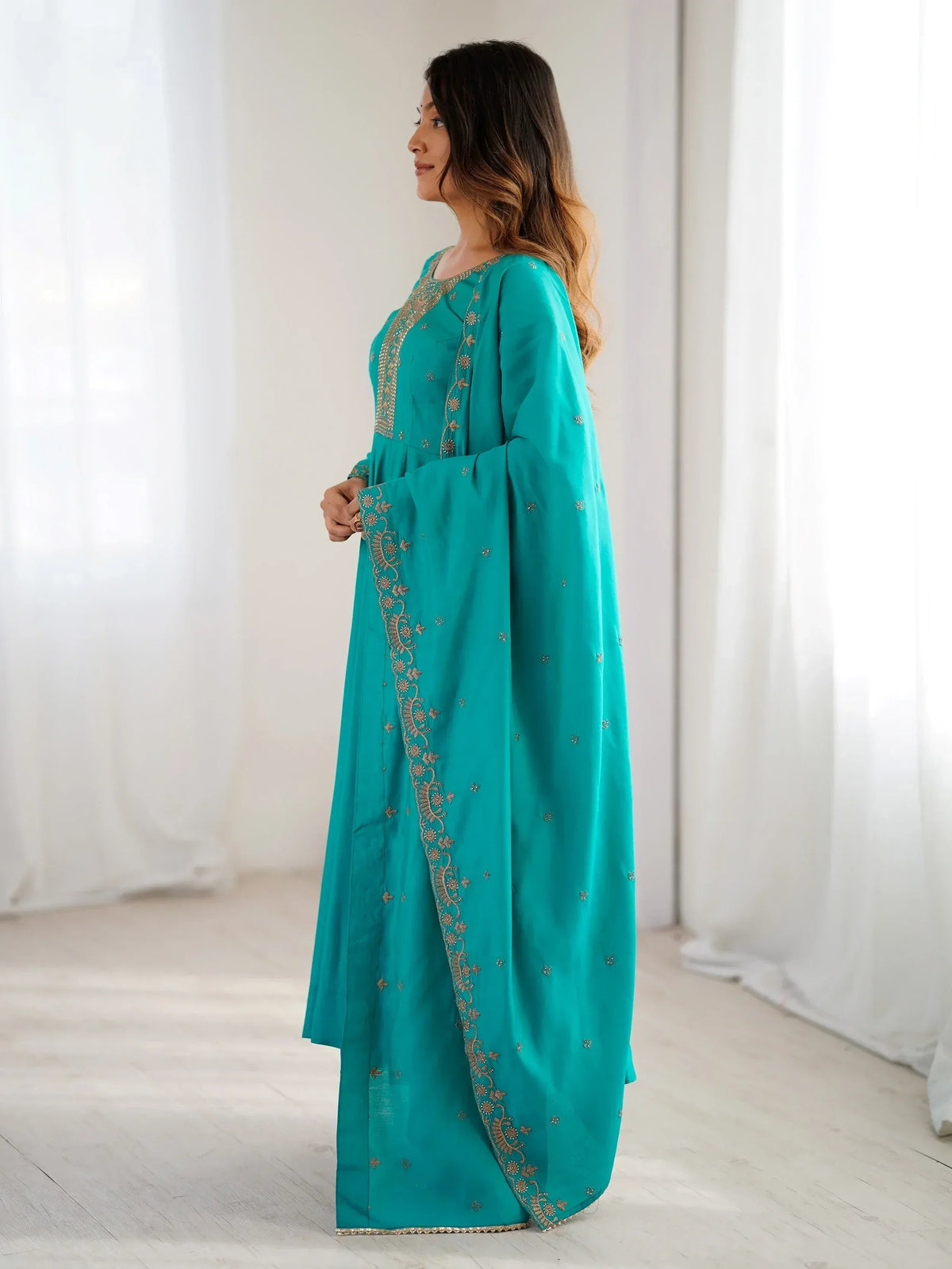 Teal ethnic gown with gold embroidery, perfect for Indian festive occasions