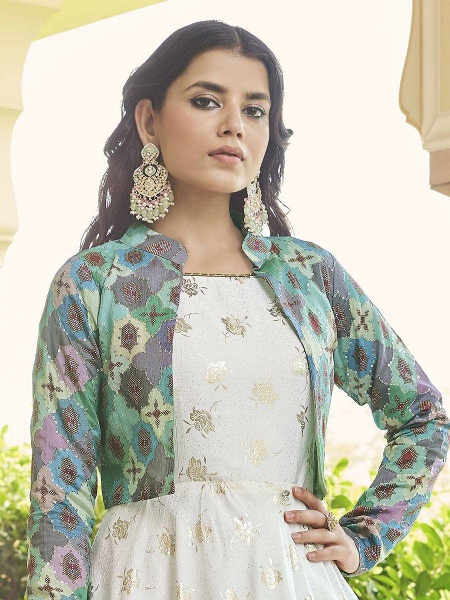 Woman in white floral gown with colorful printed jacket, ethnic Indian wear