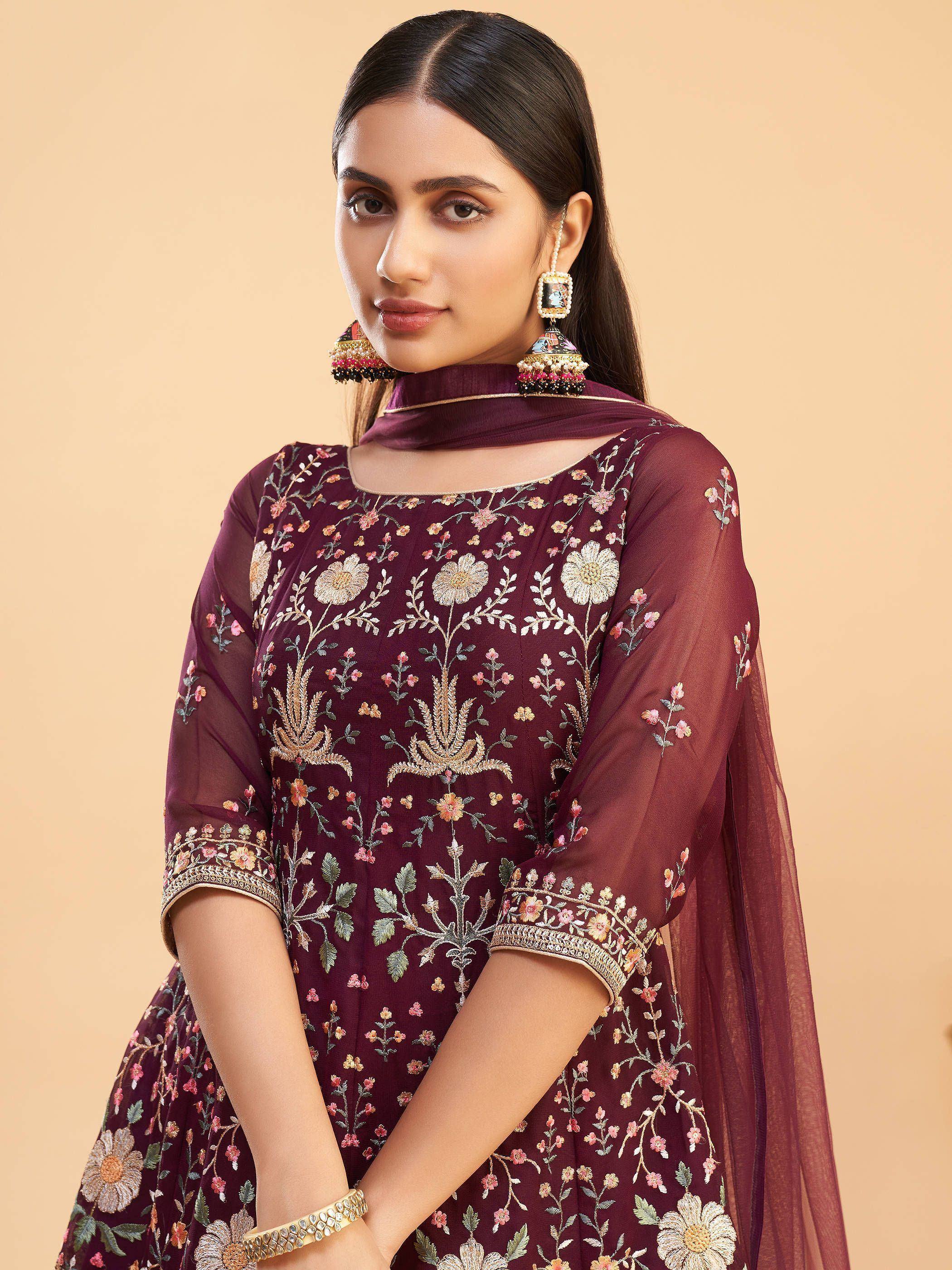 Maroon floral embroidered ethnic gown with sheer sleeves and matching dupatta, styled with traditional jhumka earrings.