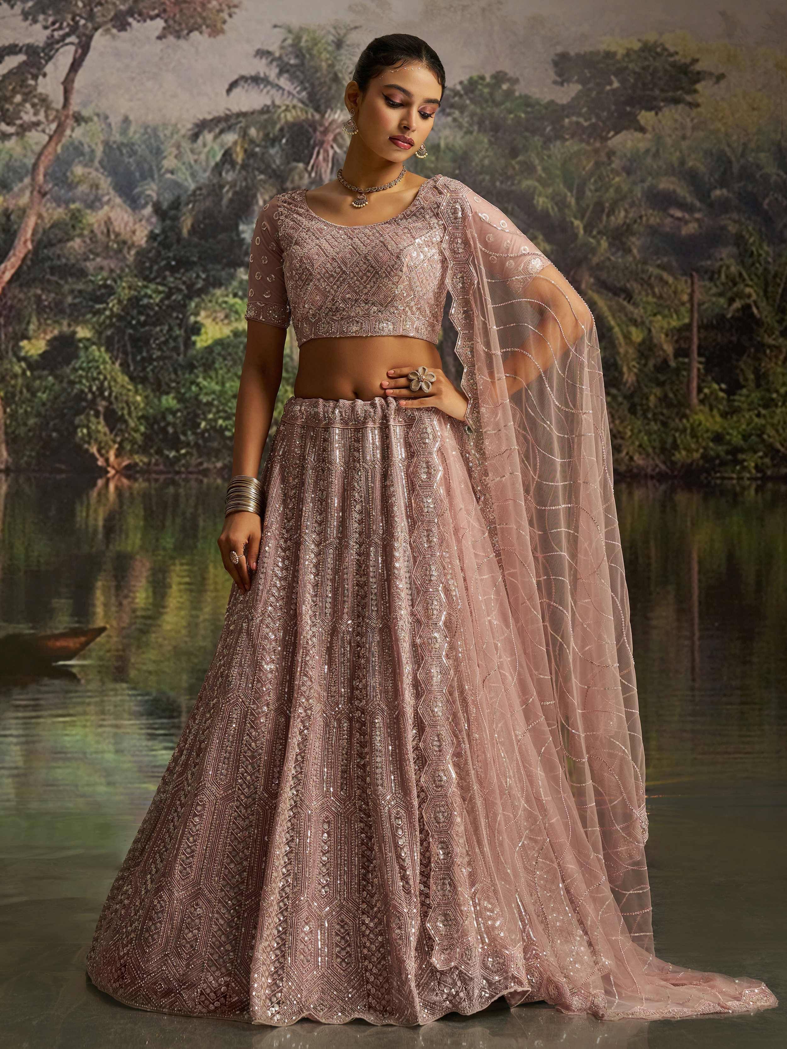 Elegant pink designer lehenga choli with intricate embroidery and sheer dupatta, perfect for Indian ethnic wear.