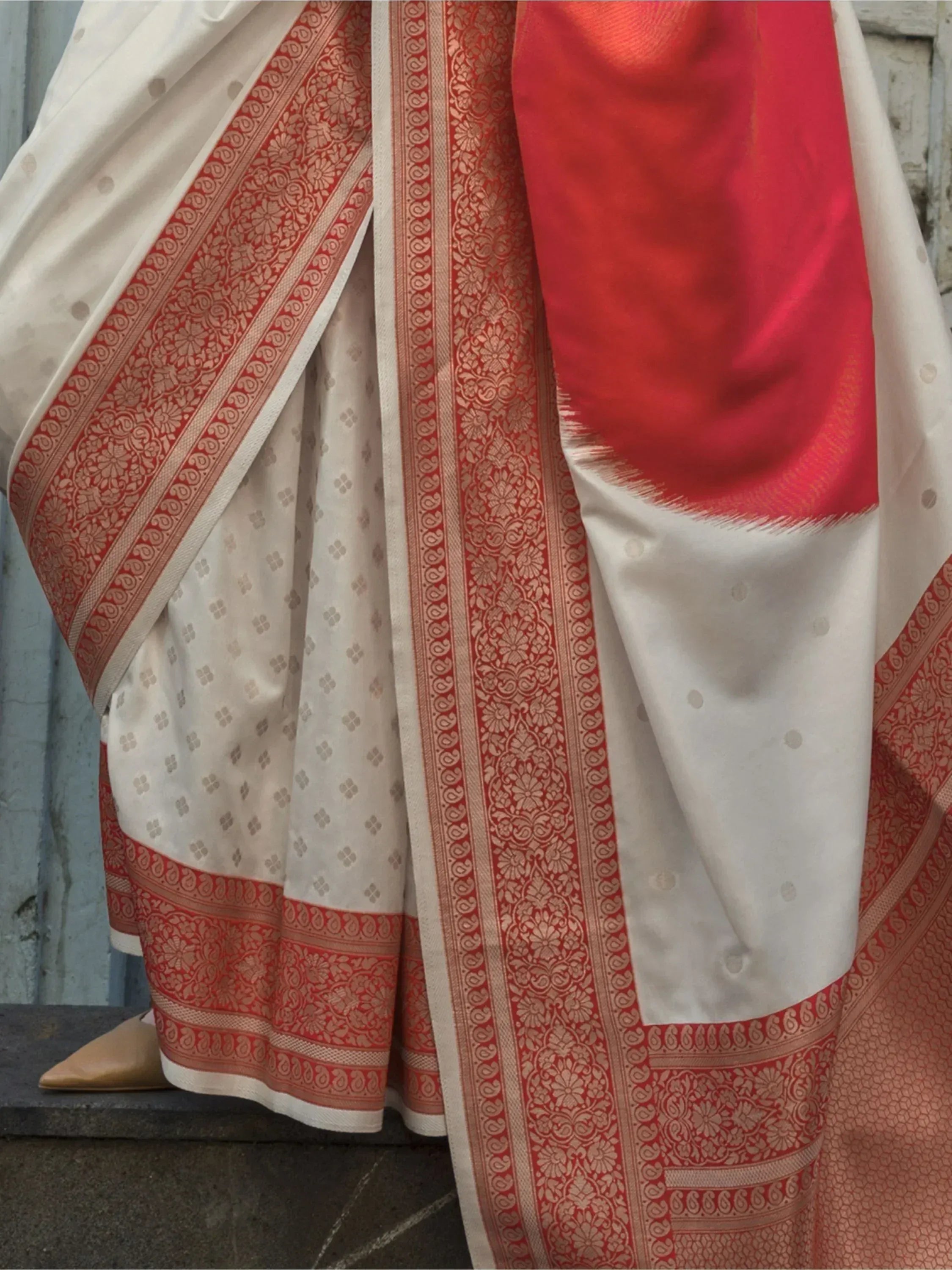 White saree with red gold border, floral motifs, and contrasting red pallu, ideal for Indian ethnic wear.