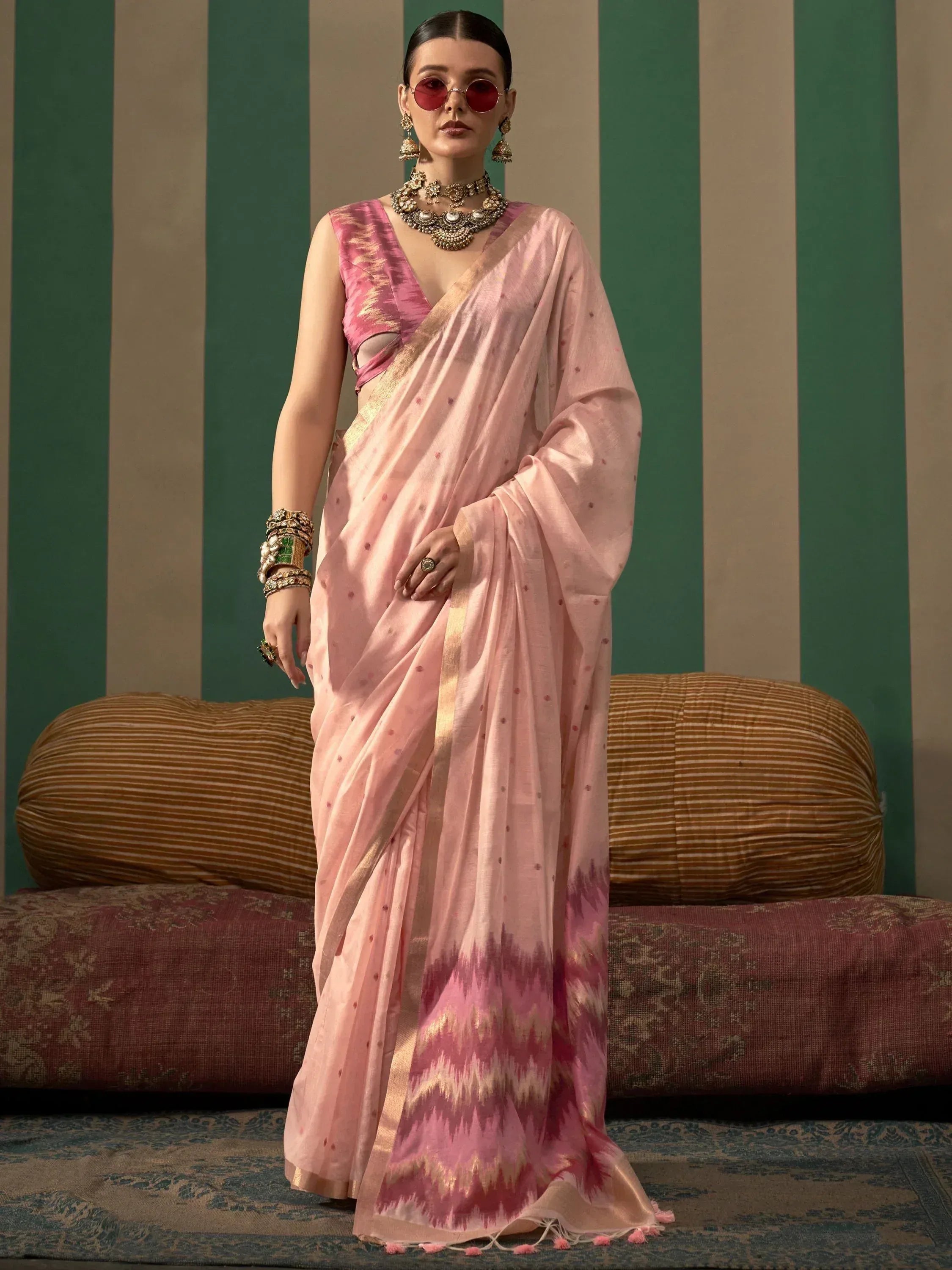 Pink ikat saree with gold border and matching blouse, styled with traditional jewelry for ethnic wear