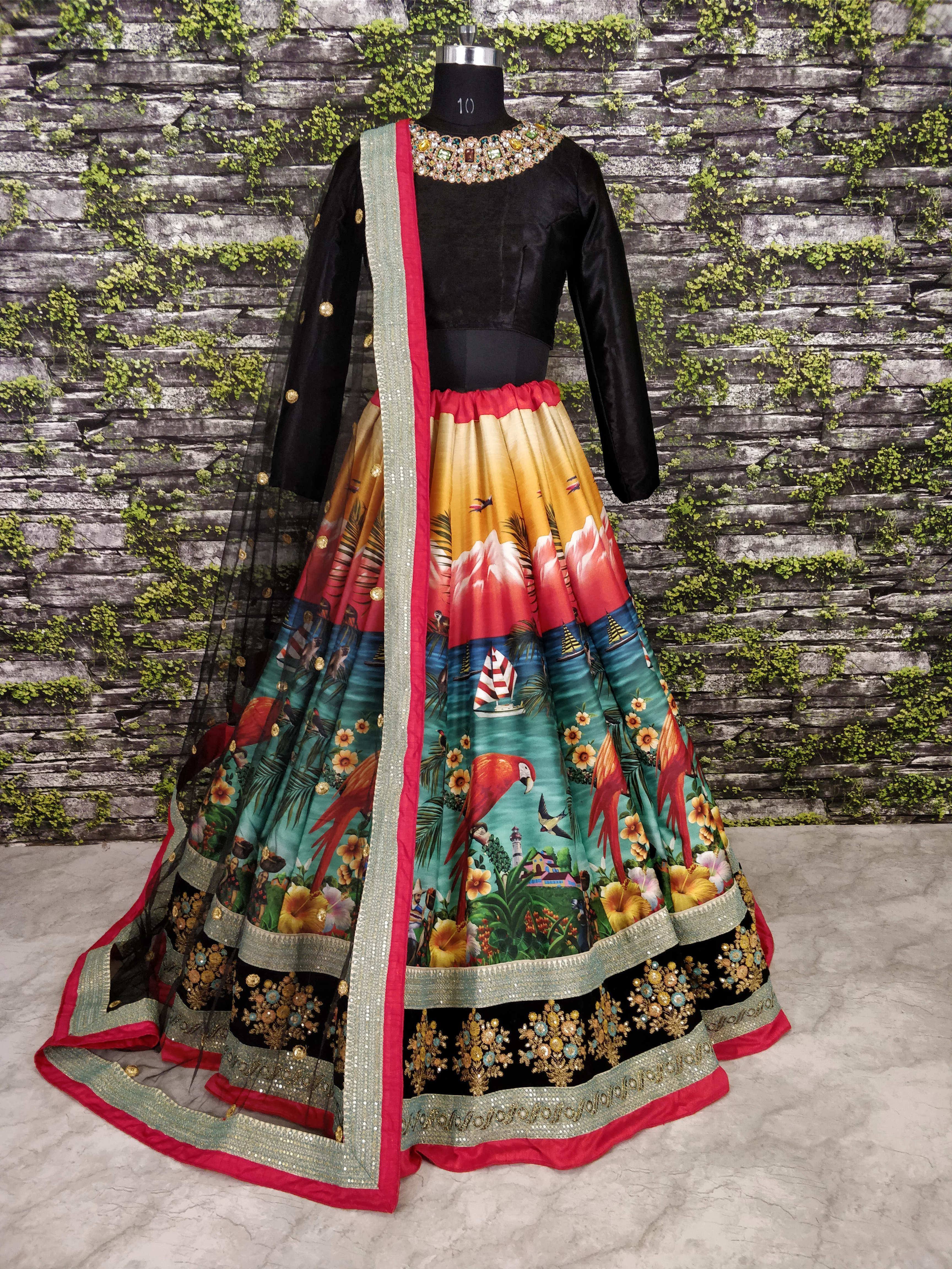 Black velvet top with colorful printed skirt featuring parrots, flowers, and landscapes, paired with embellished dupatta for ethnic wear.