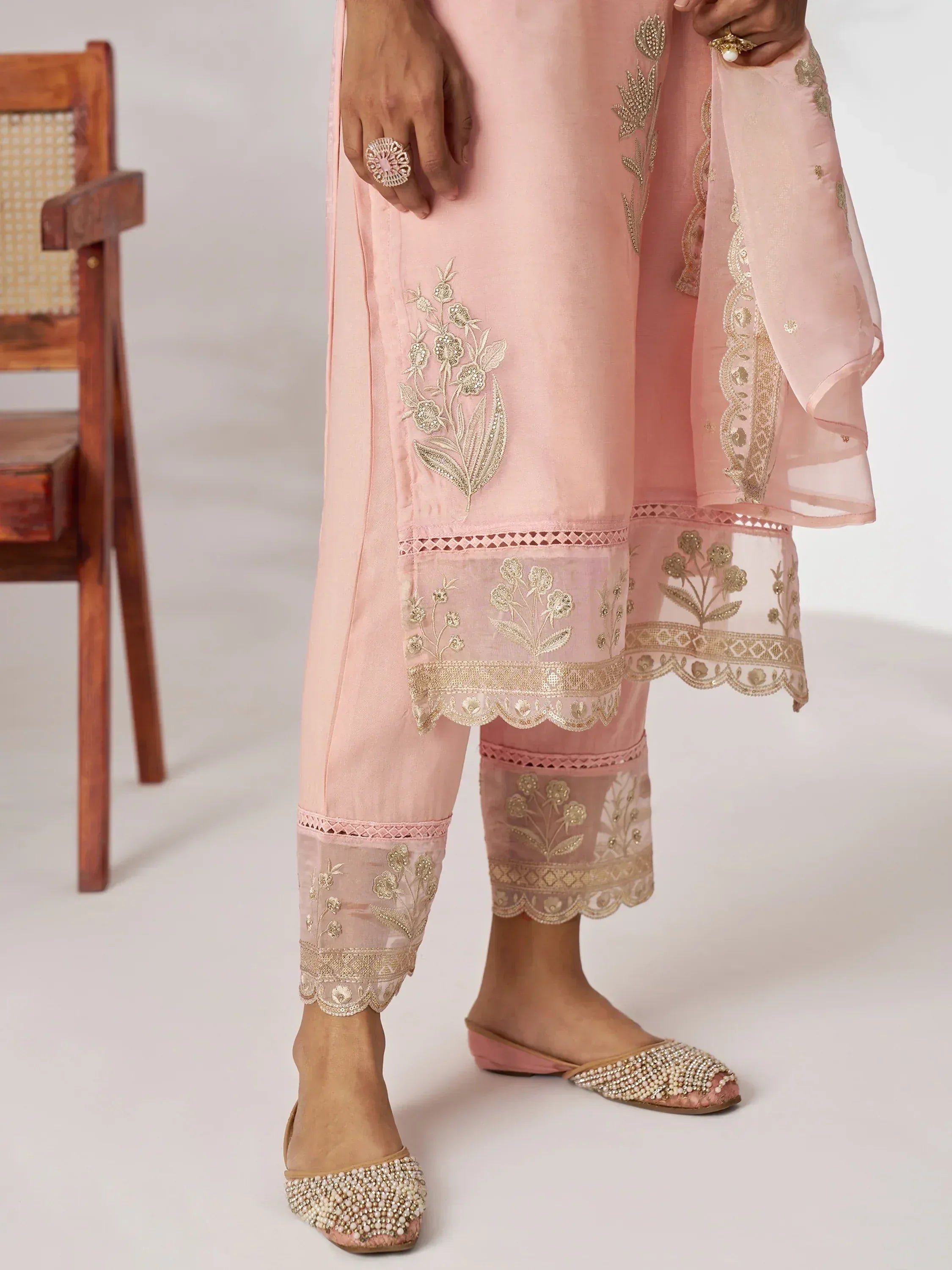 Pink embroidered salwar kameez with gold floral detailing and matching embellished flats