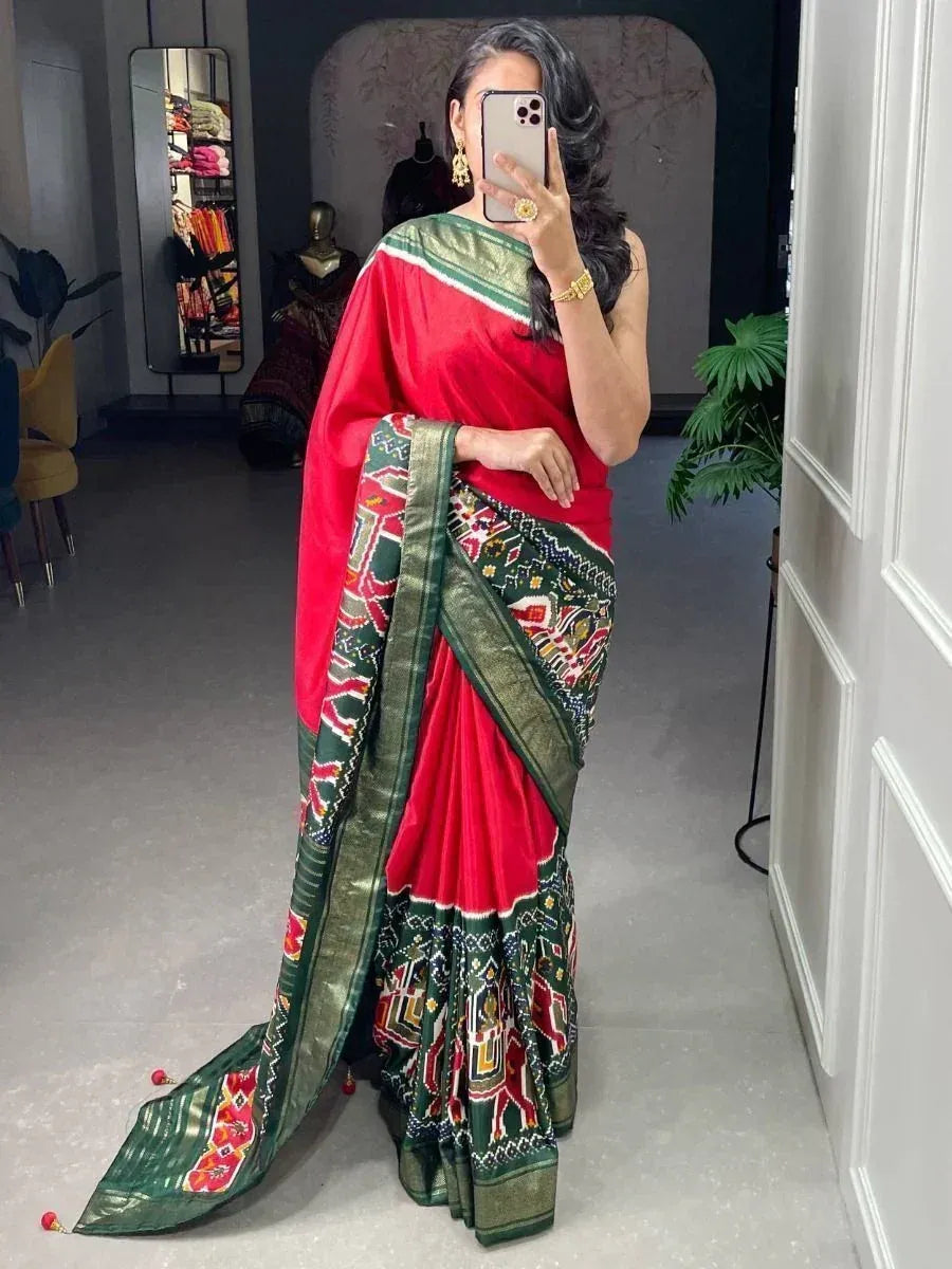 Red and green ethnic saree with intricate embroidery and border, styled for festive occasions