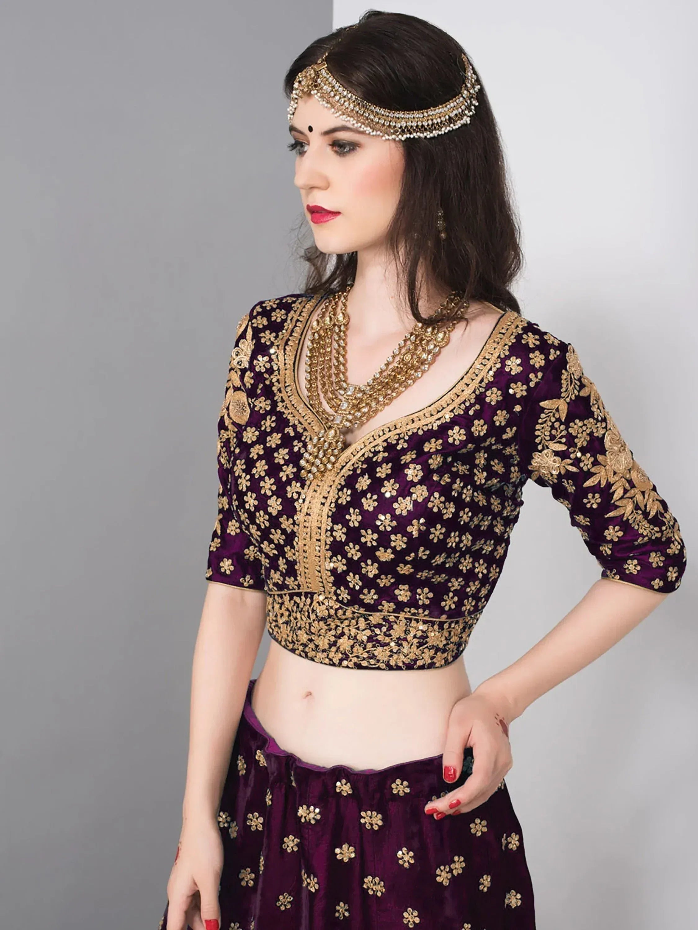 Purple velvet lehenga choli with gold floral embroidery and matching jewelry for Indian ethnic wear