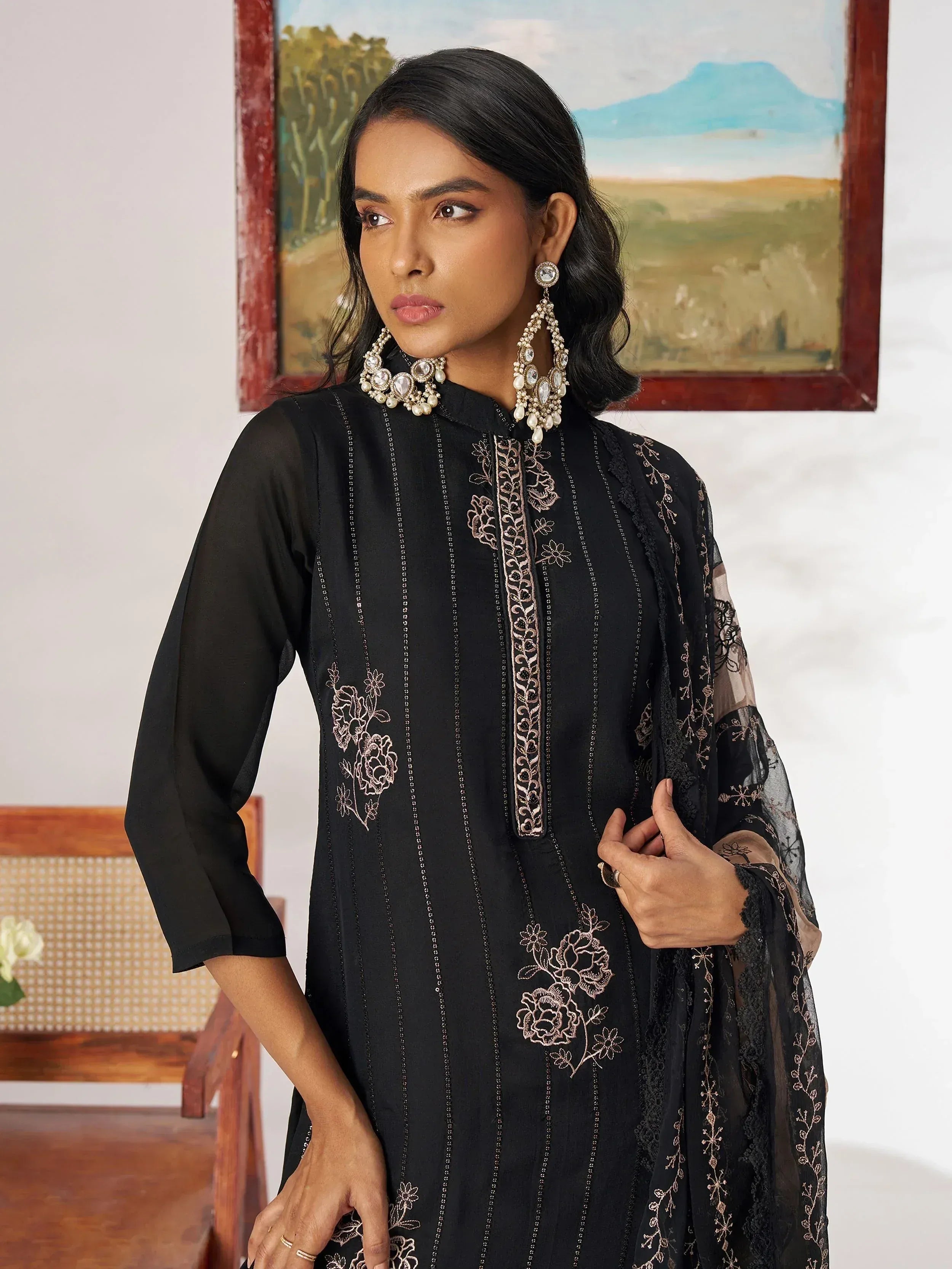 Black embroidered ethnic kurta with floral detailing and sheer sleeves, paired with statement jewelry.