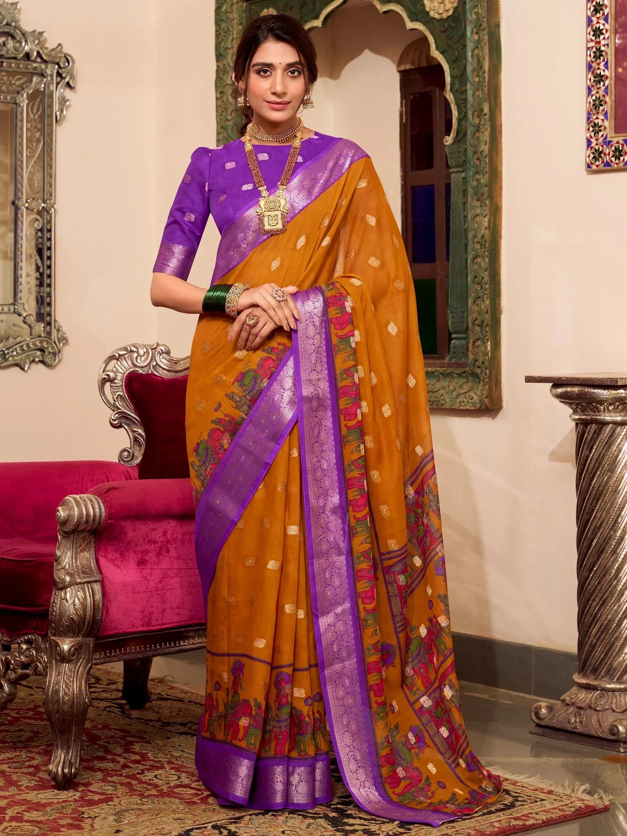 Woman in mustard and purple ethnic saree with elephant print, perfect for Indian occasions and festive wear.