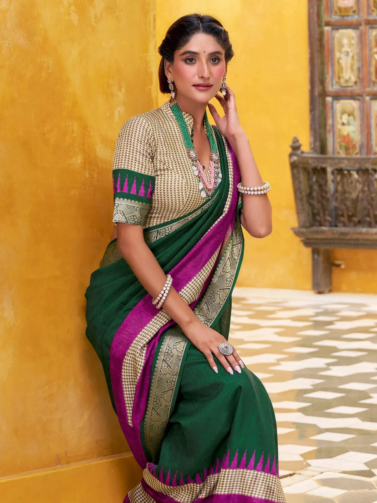 Woman in green and magenta ethnic saree with gold border, traditional Indian wear for festive occasions