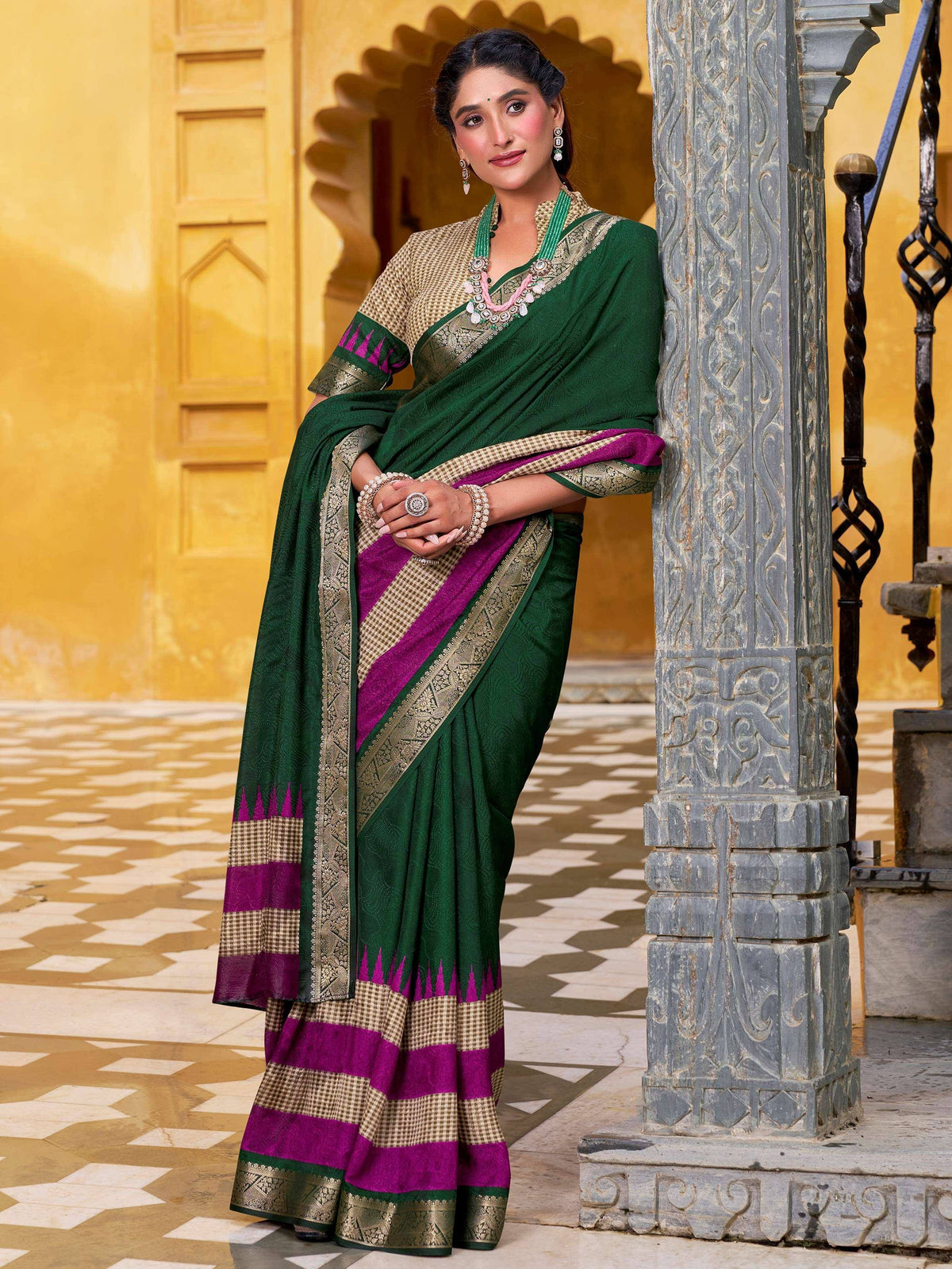 Woman in green and magenta designer saree with gold border, ethnic wear for festive occasions