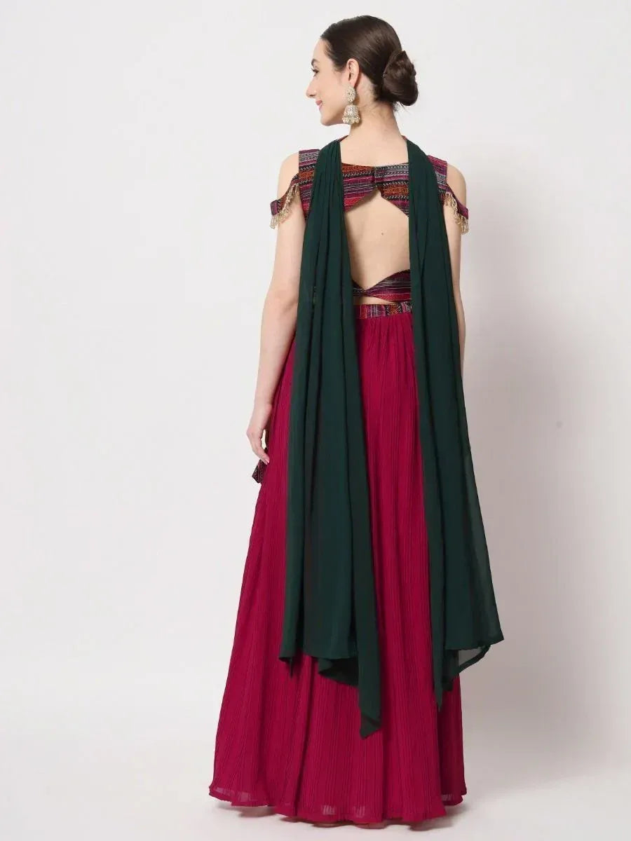 Back view of woman in maroon pleated lehenga with cold shoulder blouse and green dupatta, ethnic wear
