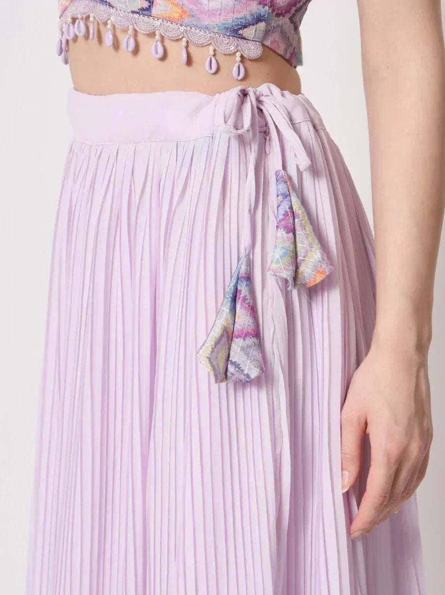 Lavender pleated ethnic skirt with drawstring waist and colorful tassels, paired with embroidered crop top